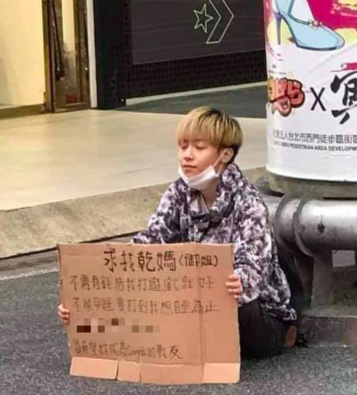 最近「阿姨,我不想努力了」成為網路流行語,一位金髮小正太在西門町舉牌「求找乾媽」。(翻攝自爆廢公社2館臉書)