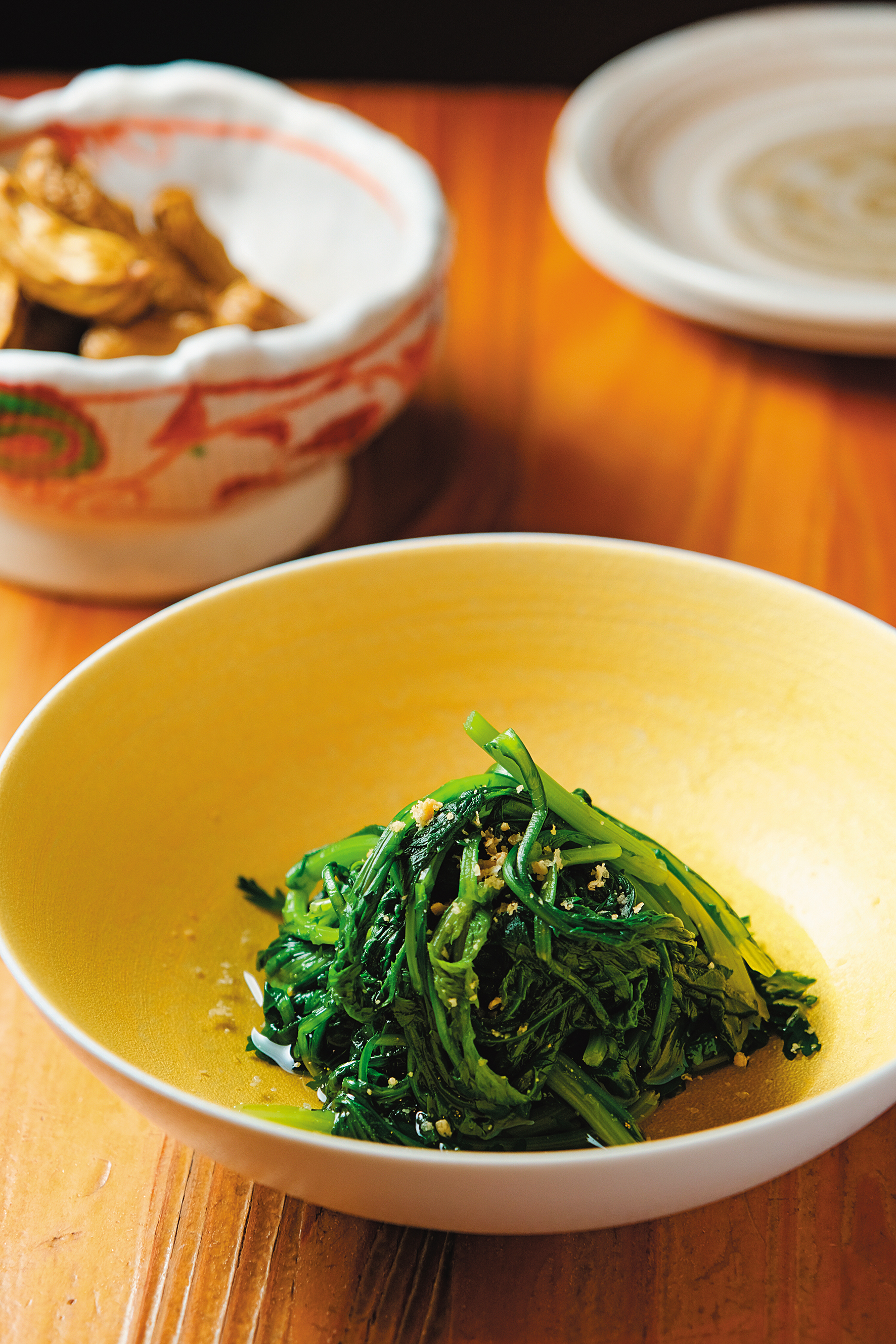 時令蔬菜如「山茼蒿浸物」（前，130元／份）和落花生醬油煮（後，160元／份）都適合搭年輕的酒。