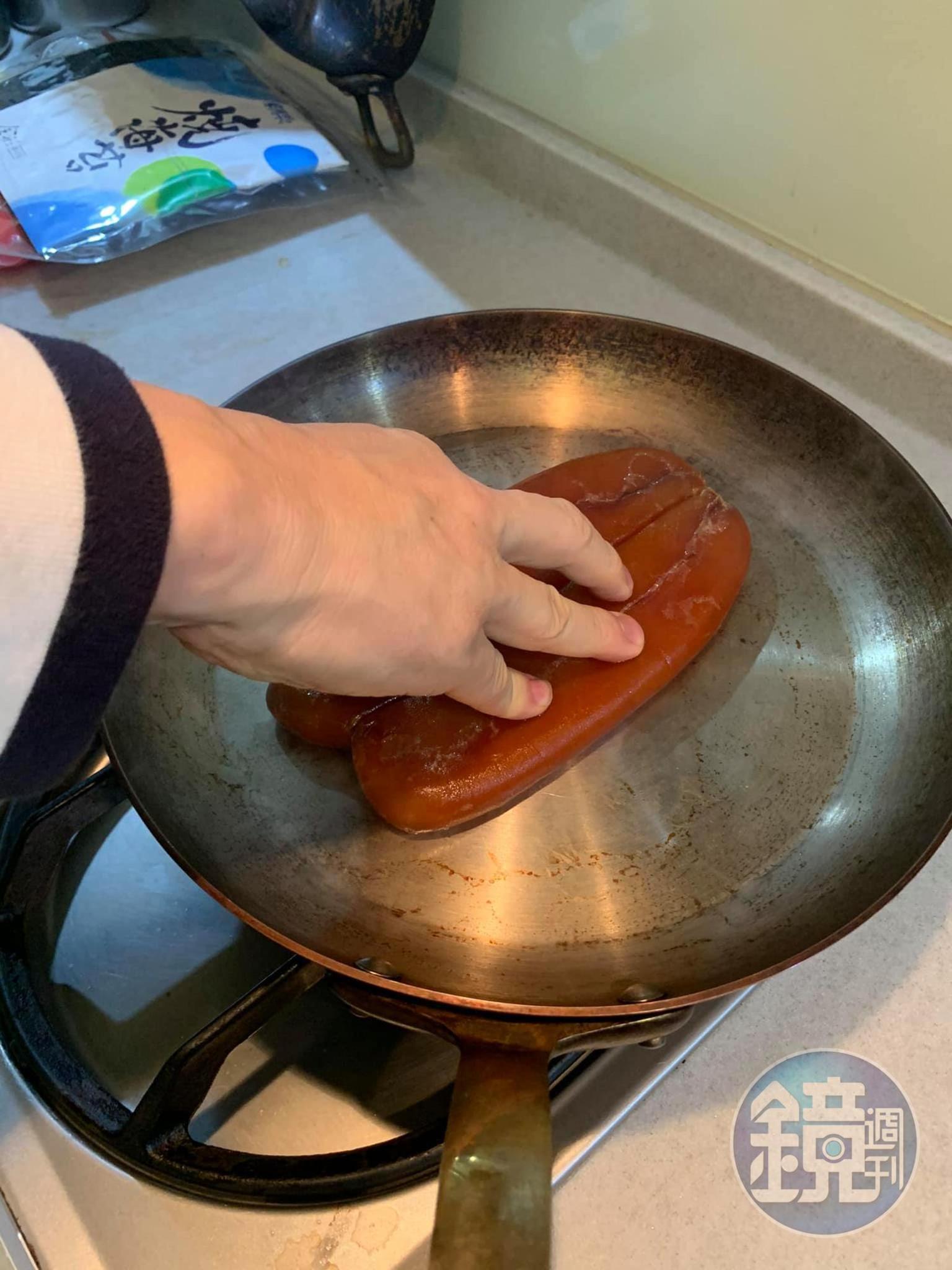 把烏魚子壓在熱鍋上。