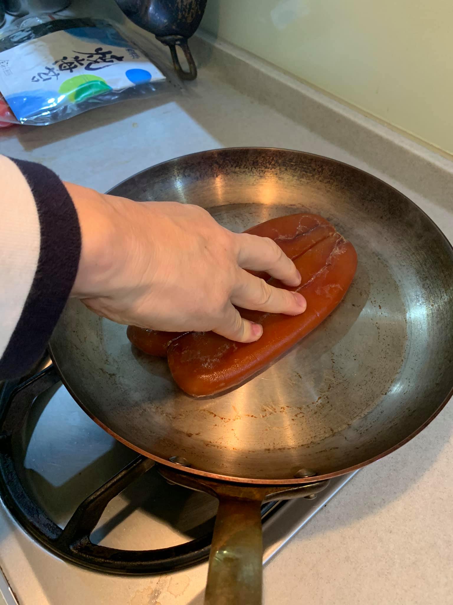 把烏魚子壓在熱鍋上。