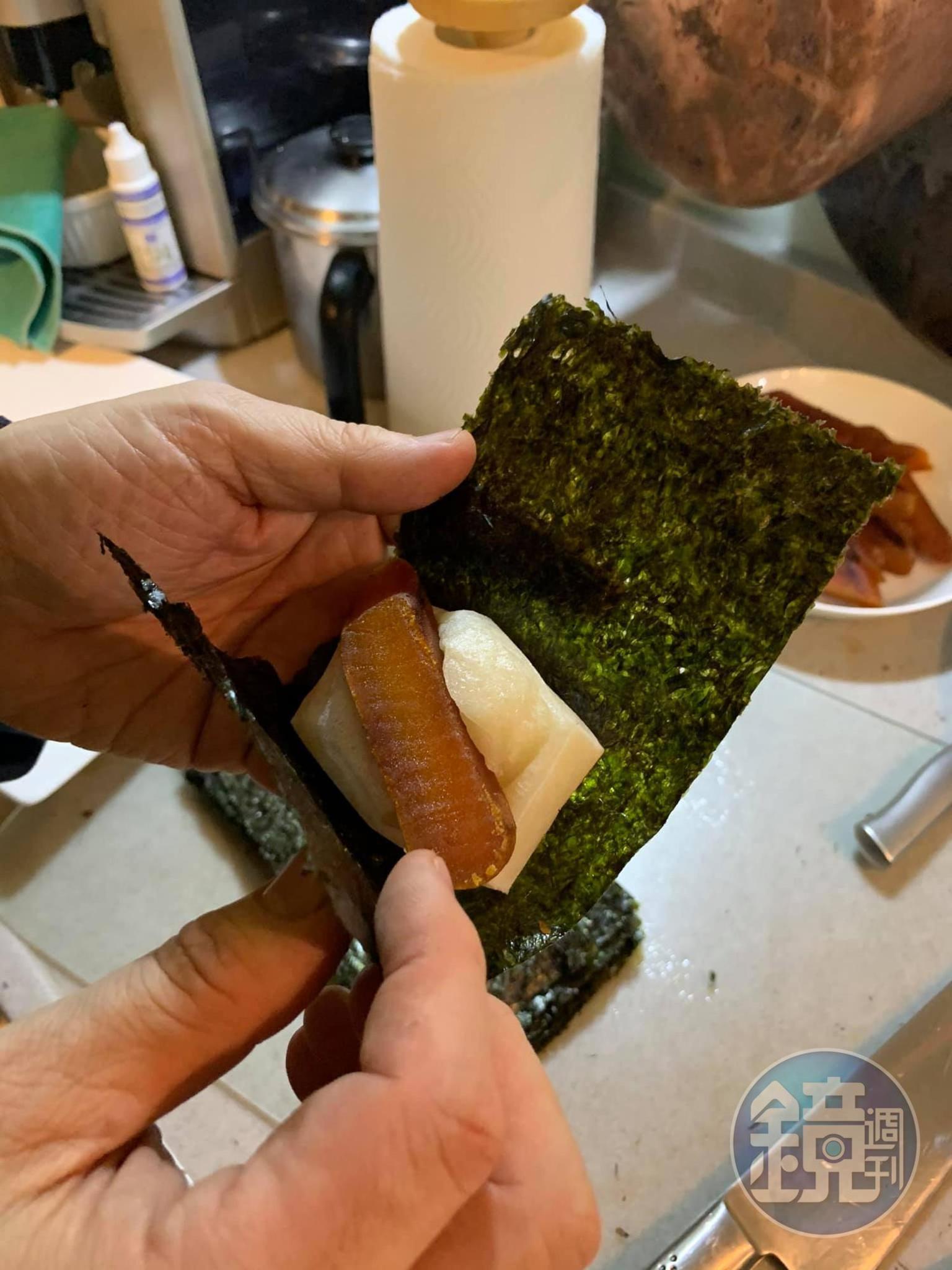 一片海苔夾一片年糕和一片烏魚子。