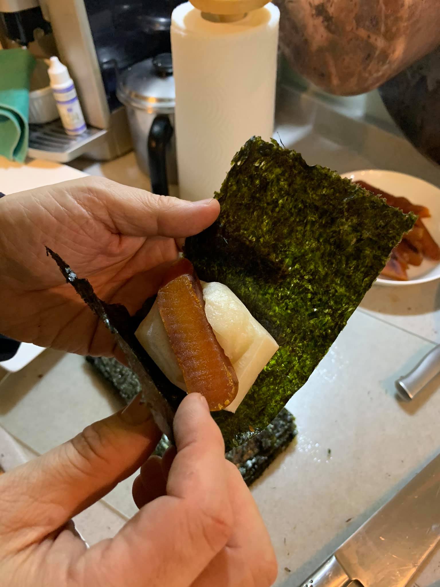 一片海苔夾一片年糕和一片烏魚子。