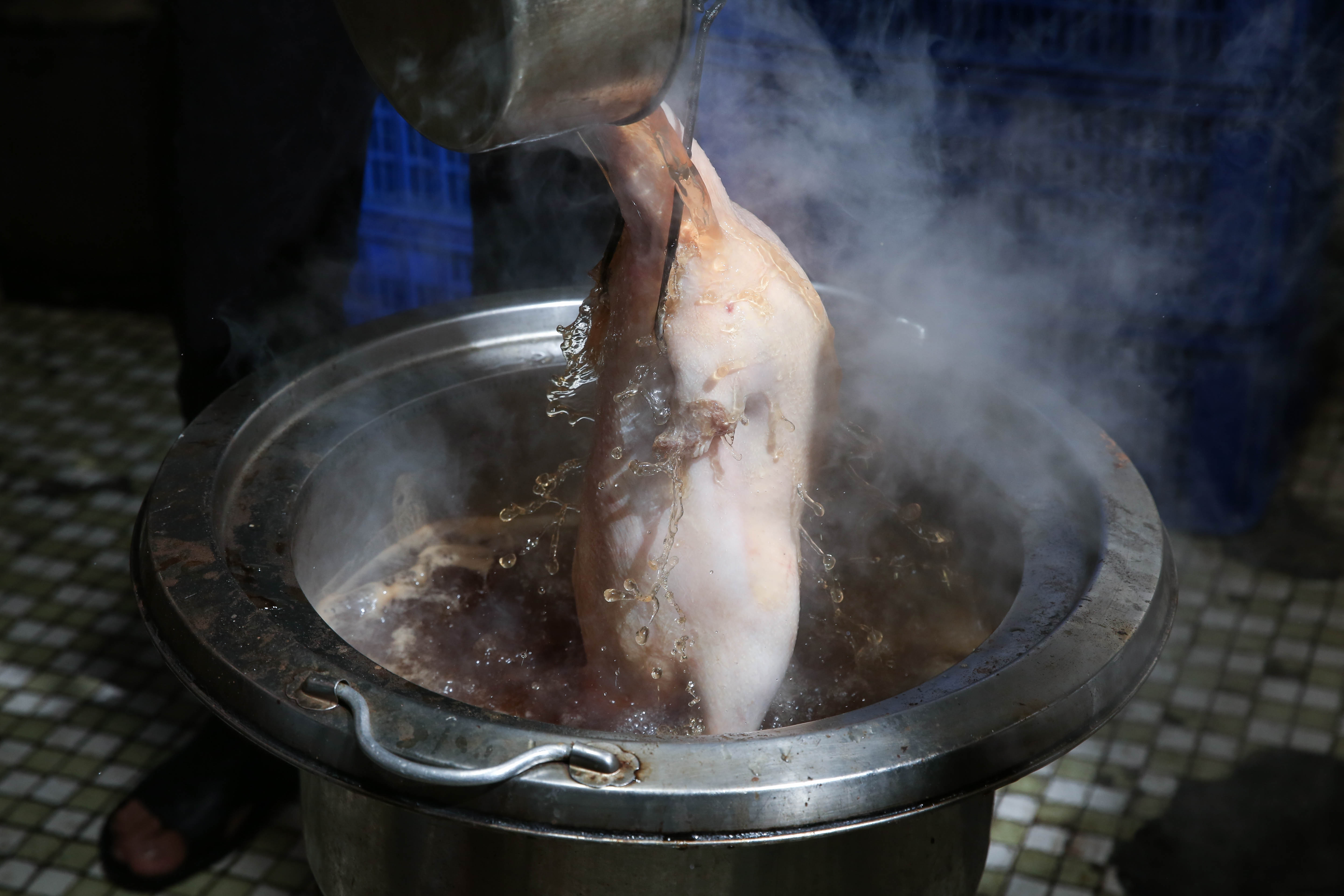 用麥芽糖調製的滾燙皮水,均勻澆淋全鴨,才能烤出漂亮顏色。