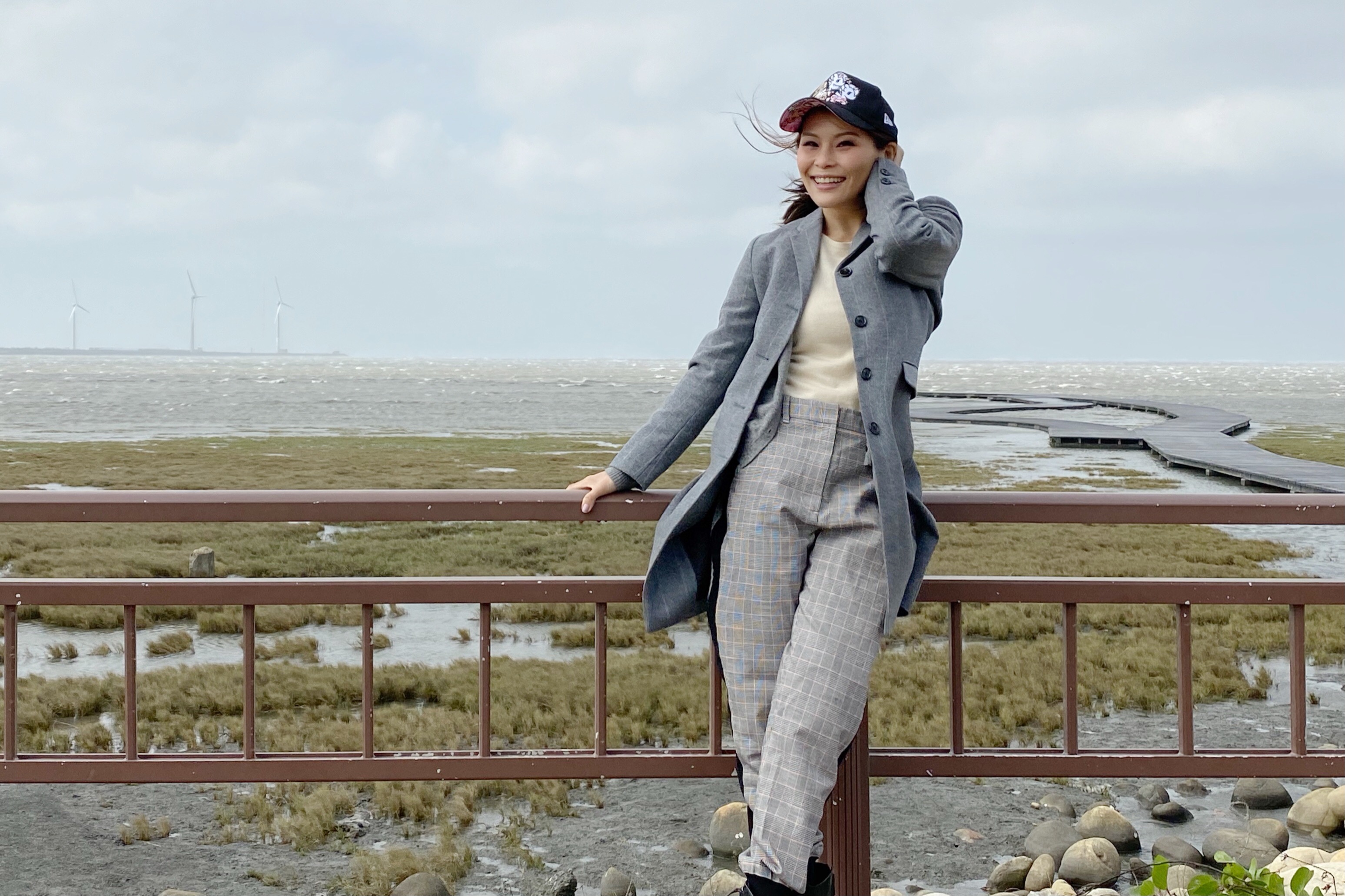 周蕙訪高美濕地遇強風頭髮顧不住。（華研國際提供）