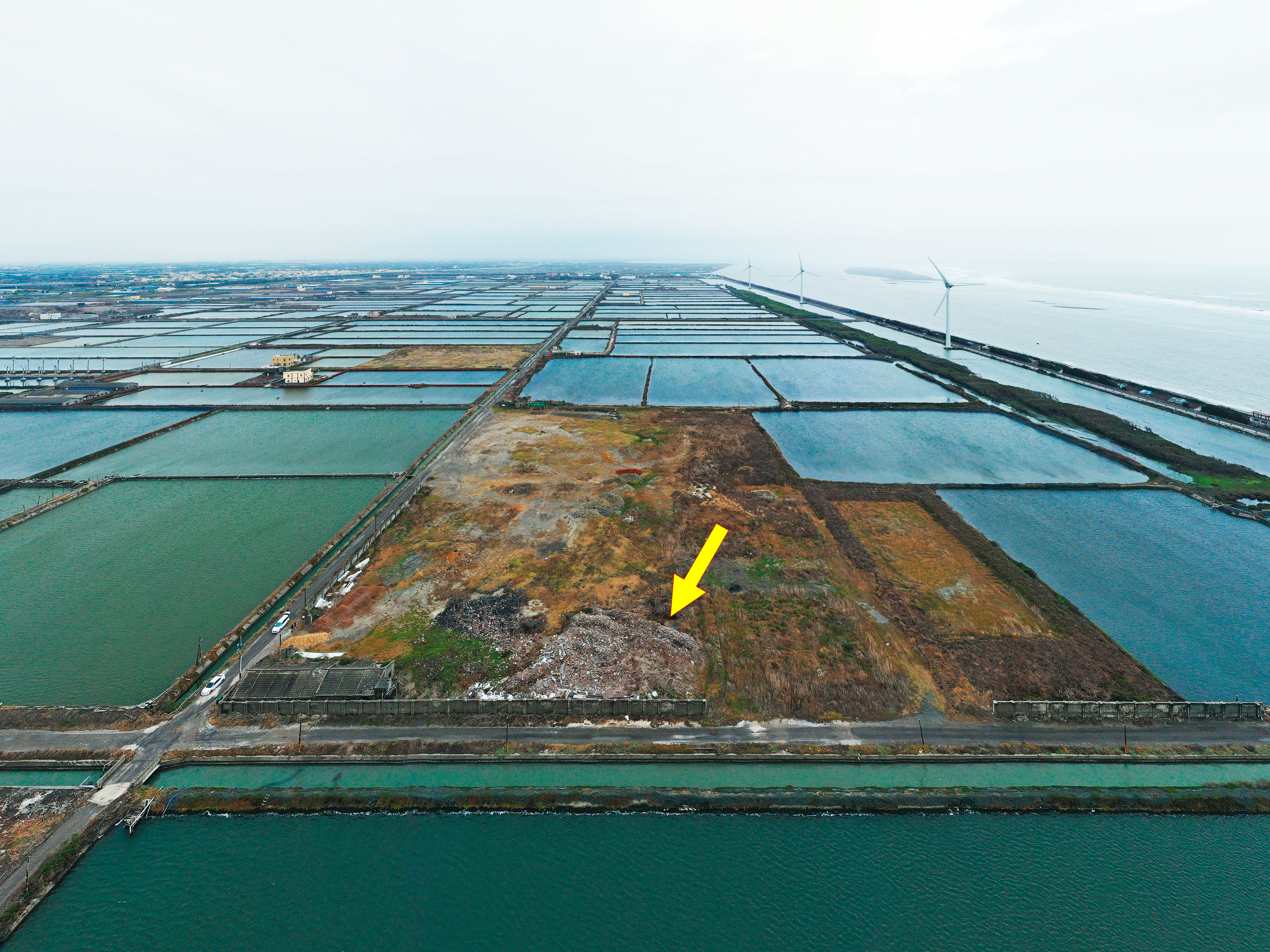 近千坪廢棄物（箭頭處）被傾倒在彰化王功海邊逾1年，周邊為蚵仔及文蛤養殖區，讓王功養殖業陷入汙染危機。