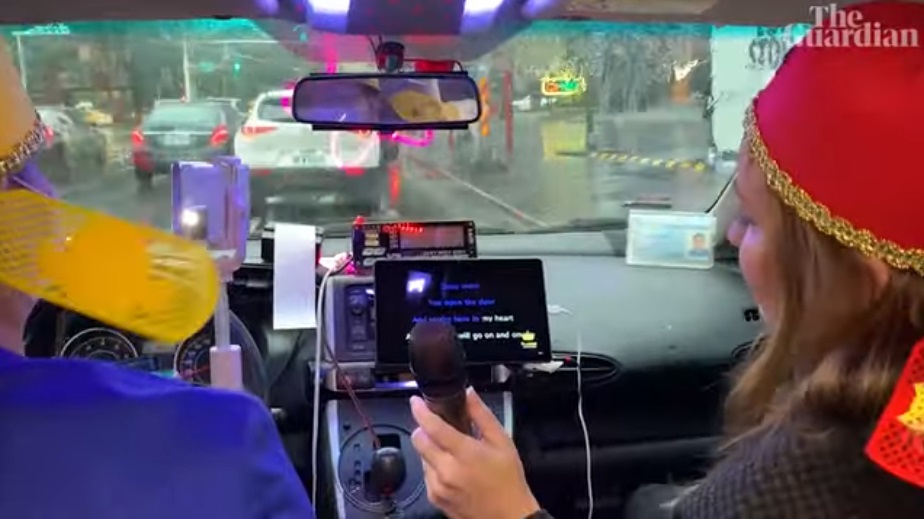 《衛報》記者海倫戴維森（右）在涂清涼車上唱《鐵達尼號》主題曲。（翻攝《衛報》影片）