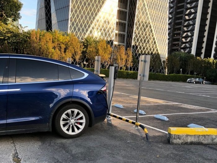 特斯拉車主被網友爆料「停在停車場外」省錢充電。（翻攝自Dcard）