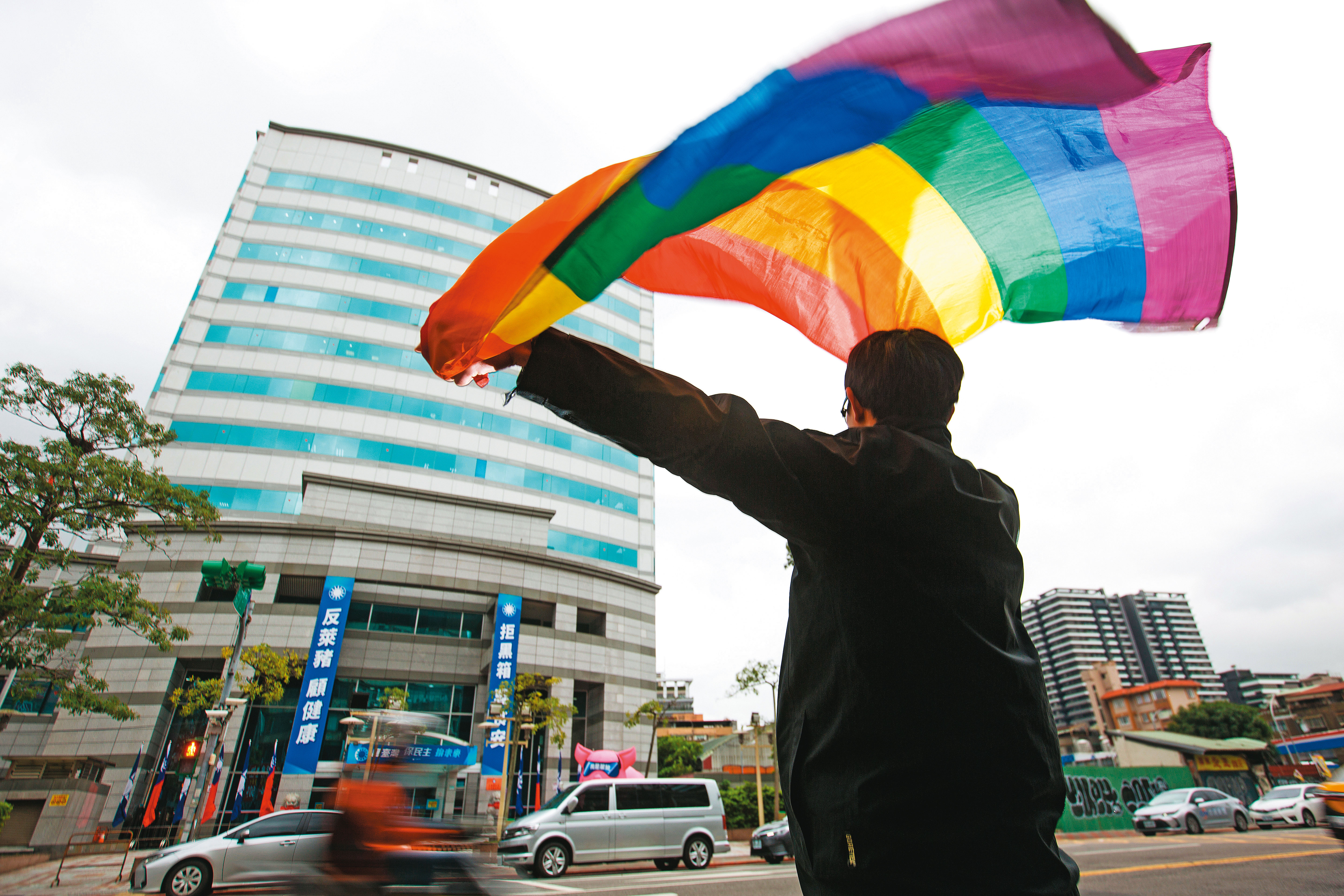 同婚合法後，泛藍傾向的同志成為社群裡的少數，在國民黨面前揚起彩虹旗是一件五味雜陳的事。照片裡的建築為國民黨黨部。