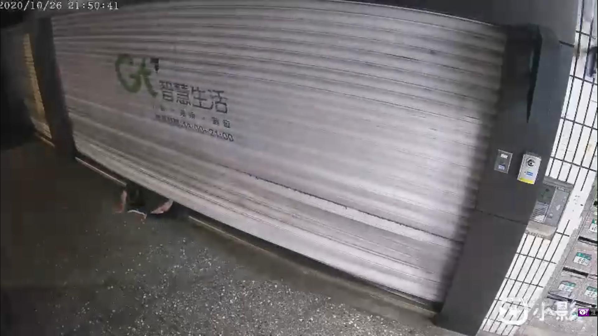 淡水亞太電信員工在進入店內時,突然遭失速墜落的鐵門壓身,身體呈現「對半折」狀態。(翻攝畫面)