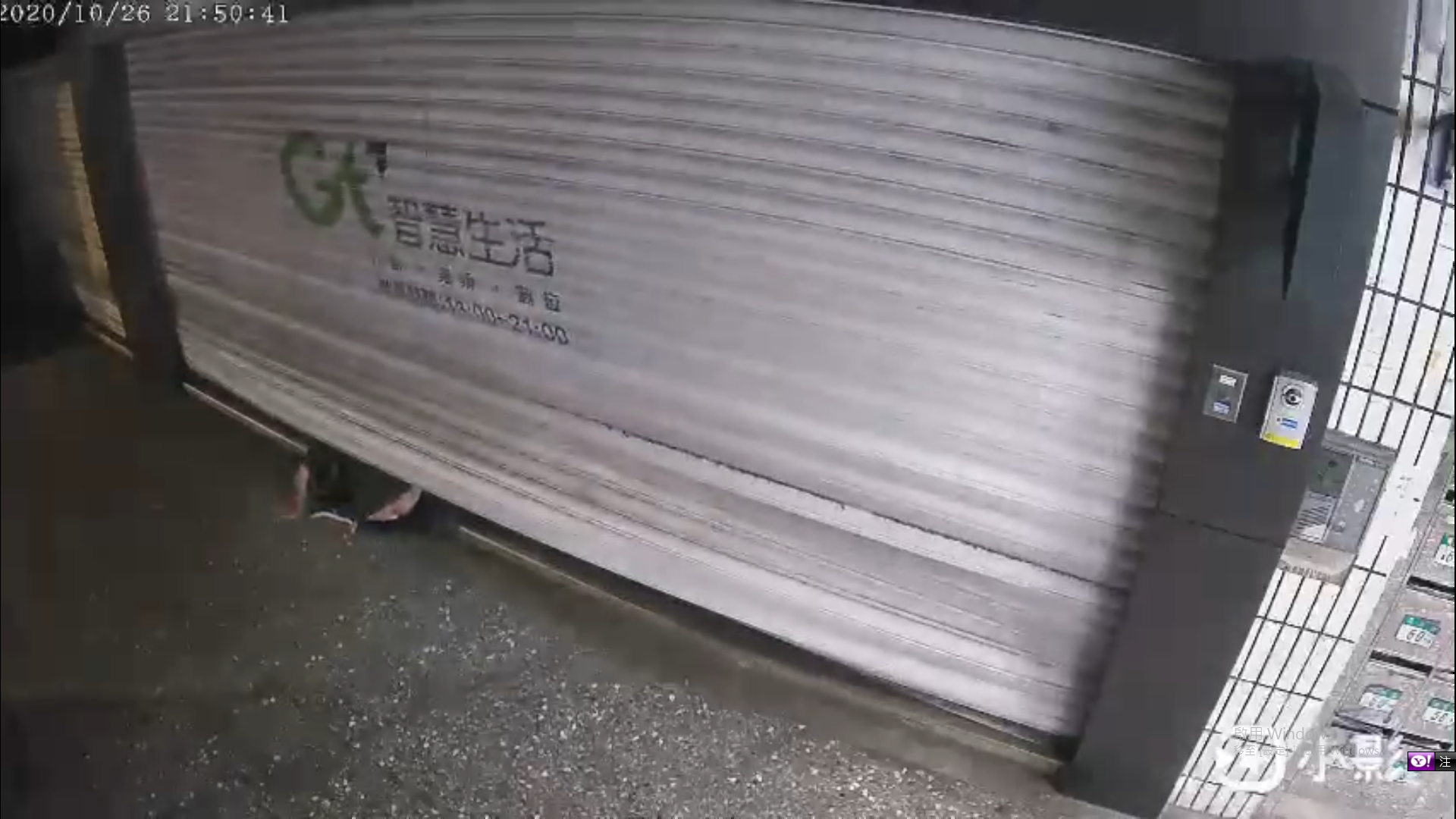 淡水亞太電信員工在進入店內時，突然遭失速墜落的鐵門壓身，身體呈現「對半折」狀態。（翻攝畫面）