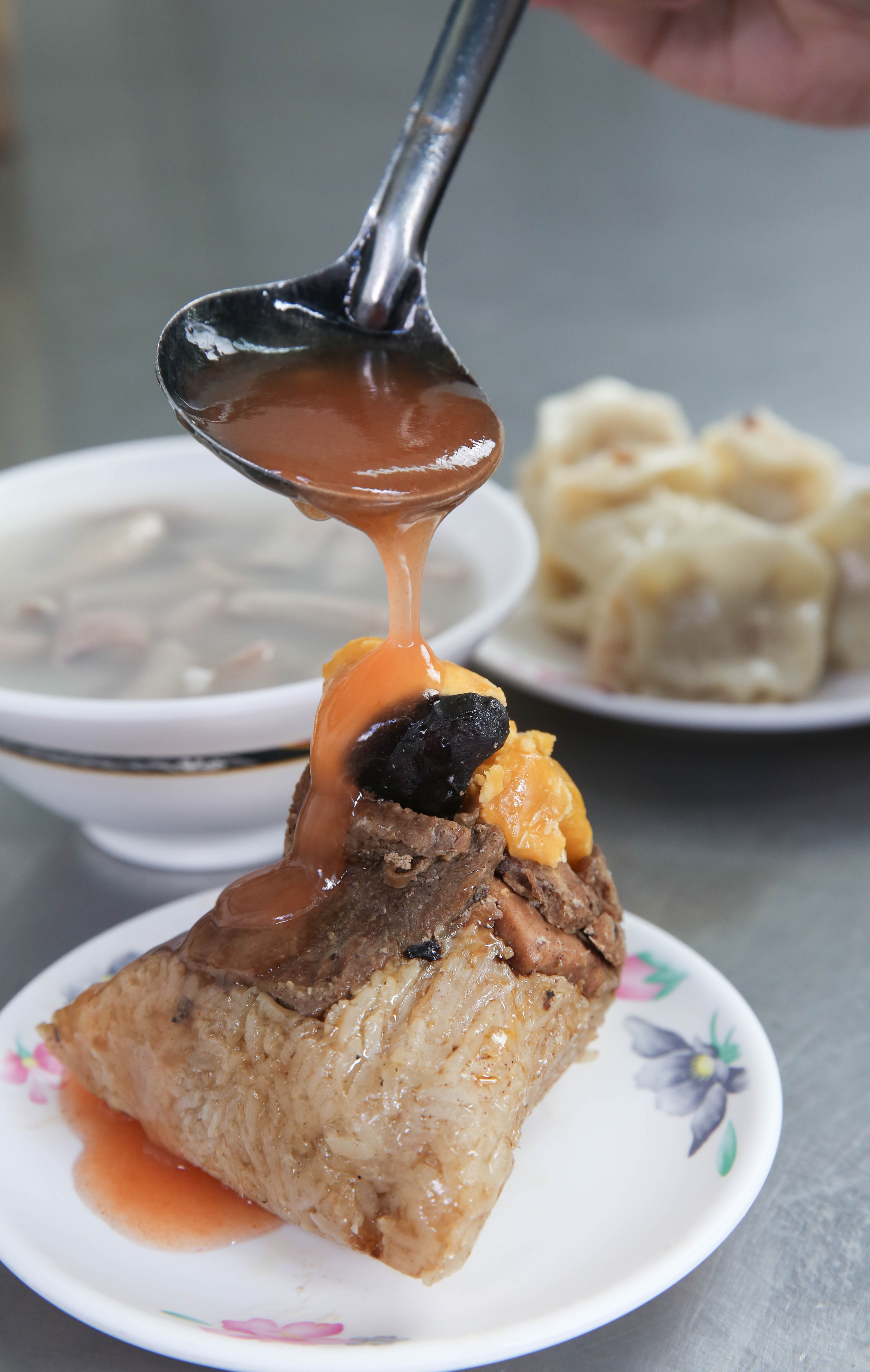 店內販售的北部粽，包入大塊豬肉與蛋黃，搭配自家熬煮的醬汁很對味。（50元/顆）