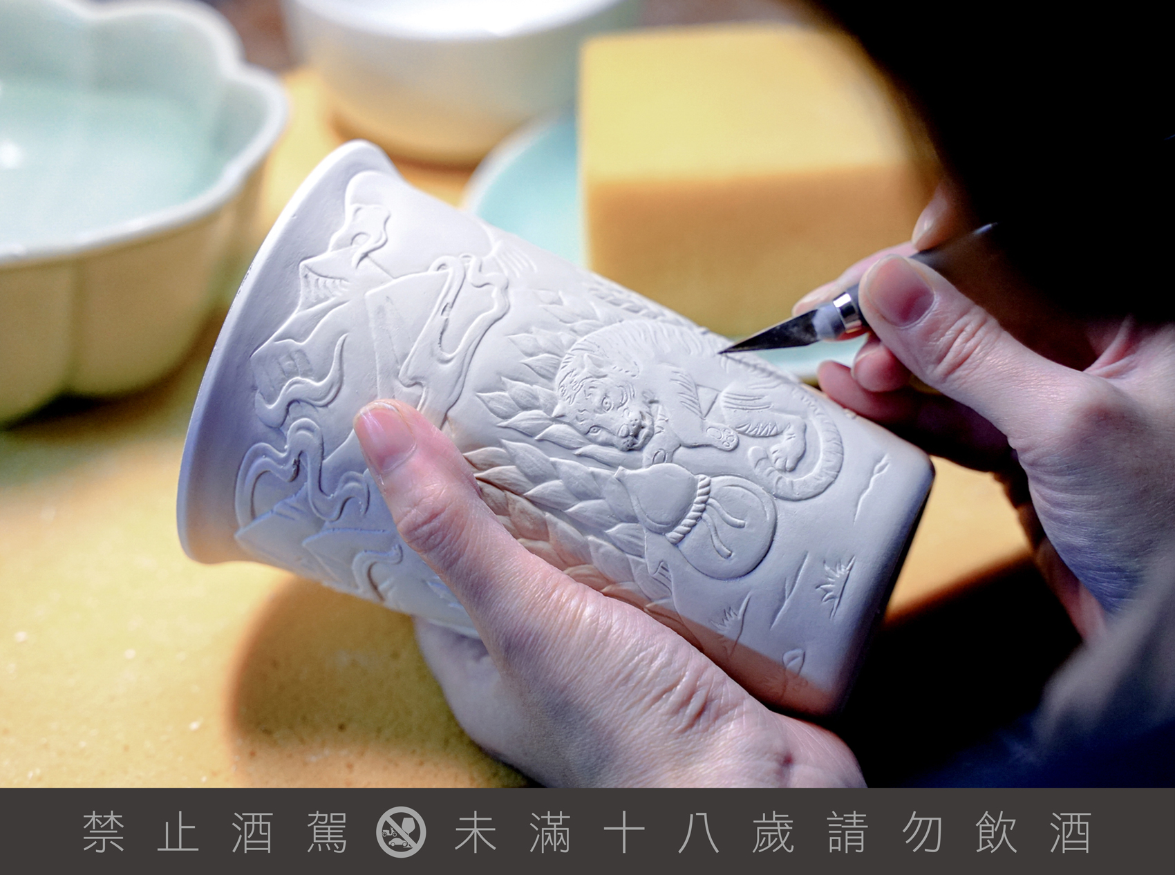 用刀刻畫出或深或淺的線條取代寫實畫法,利用簡約的線條讓畫面更加立體,一同將「涉水取酒花的水牛、爬山採麥穗的猛虎」呈現於青瓷杯面。(臺虎精釀提供)