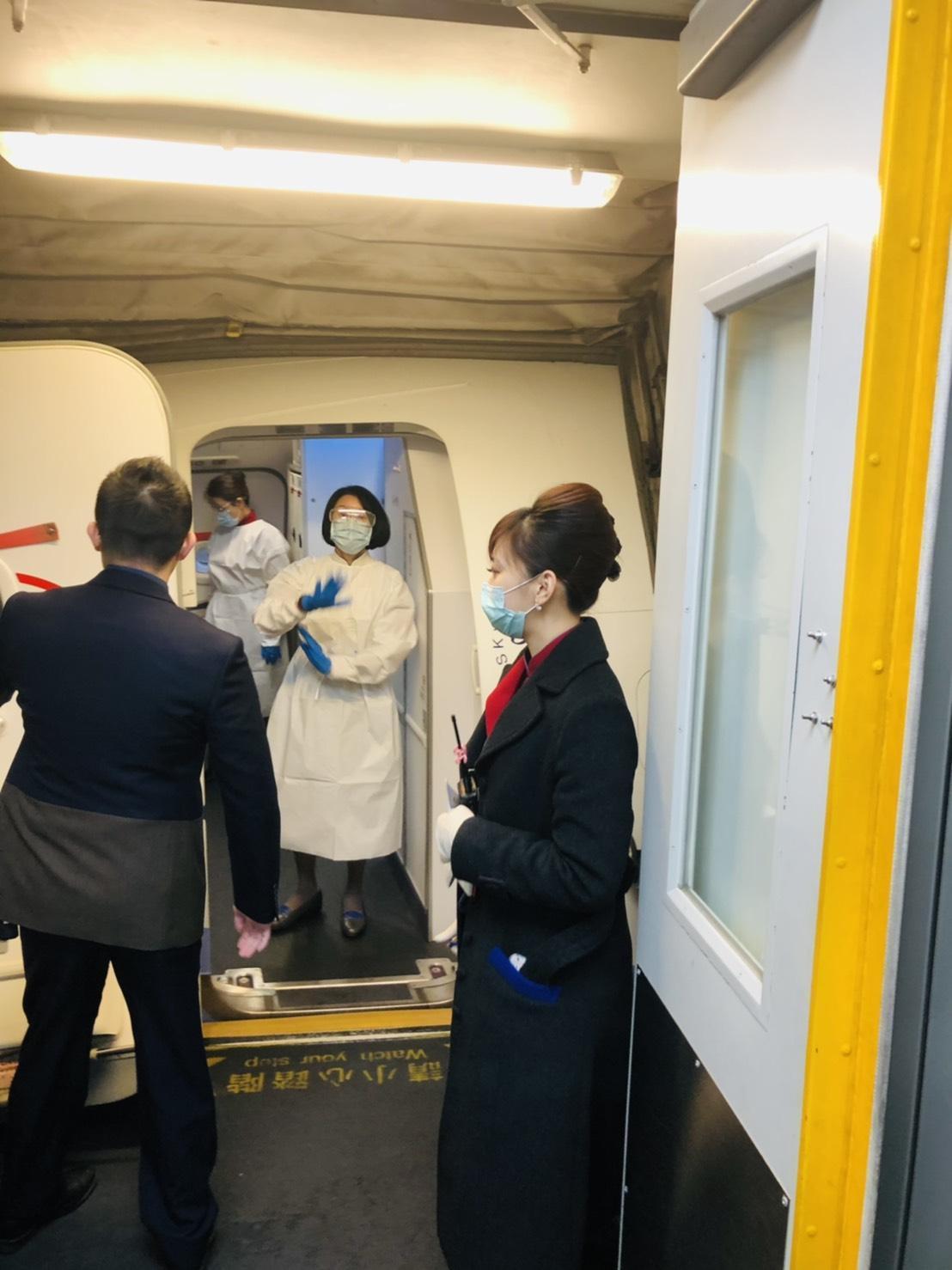 華航關島返台的「人道包機」，空服人員全副武裝防疫。（中華航空提供）
