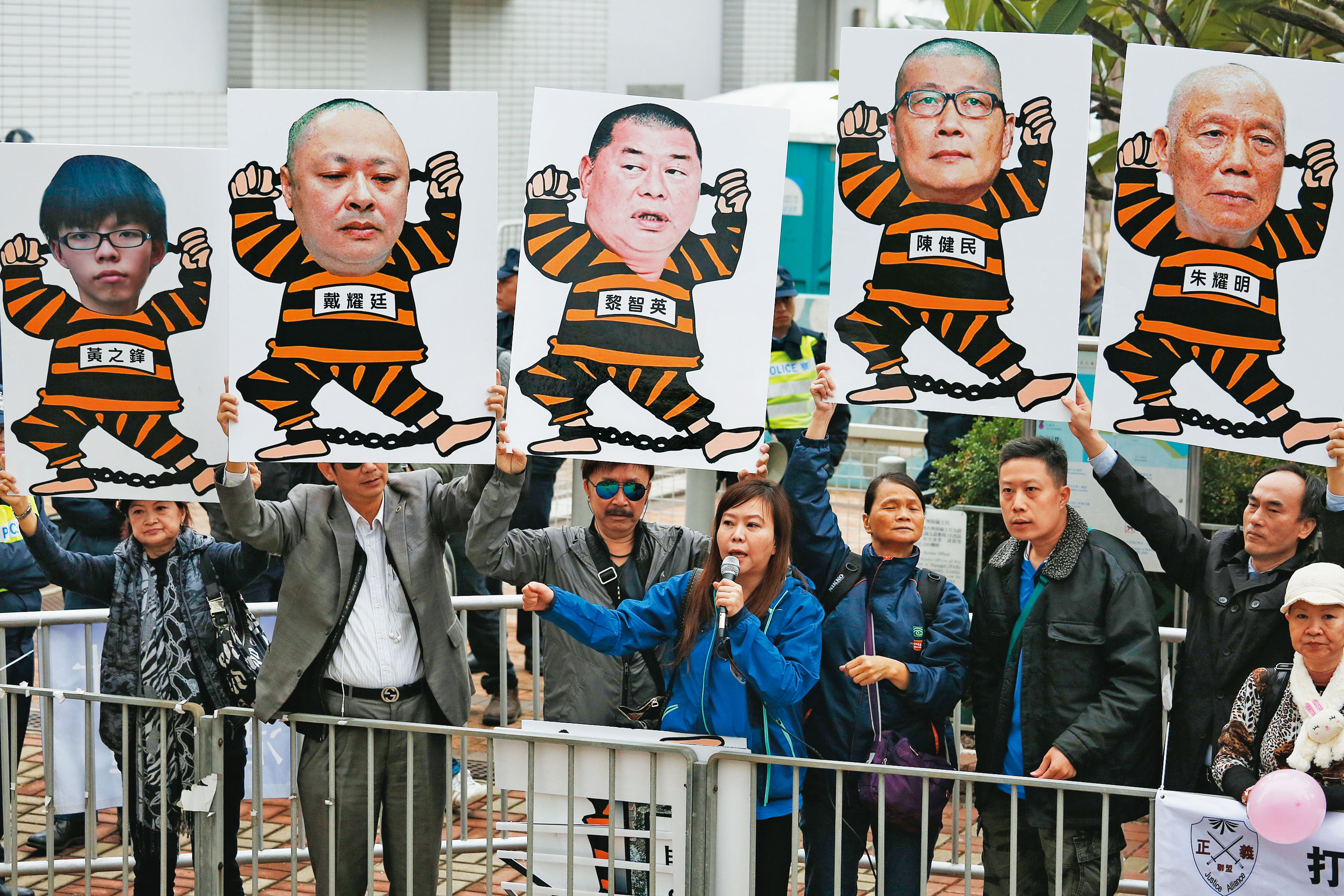 2014年12月3日,反對占領中環運動者手持諷刺漫畫,譏諷運動要角黃之鋒、戴耀廷、黎智英、陳健民與朱耀明。(達志影像)