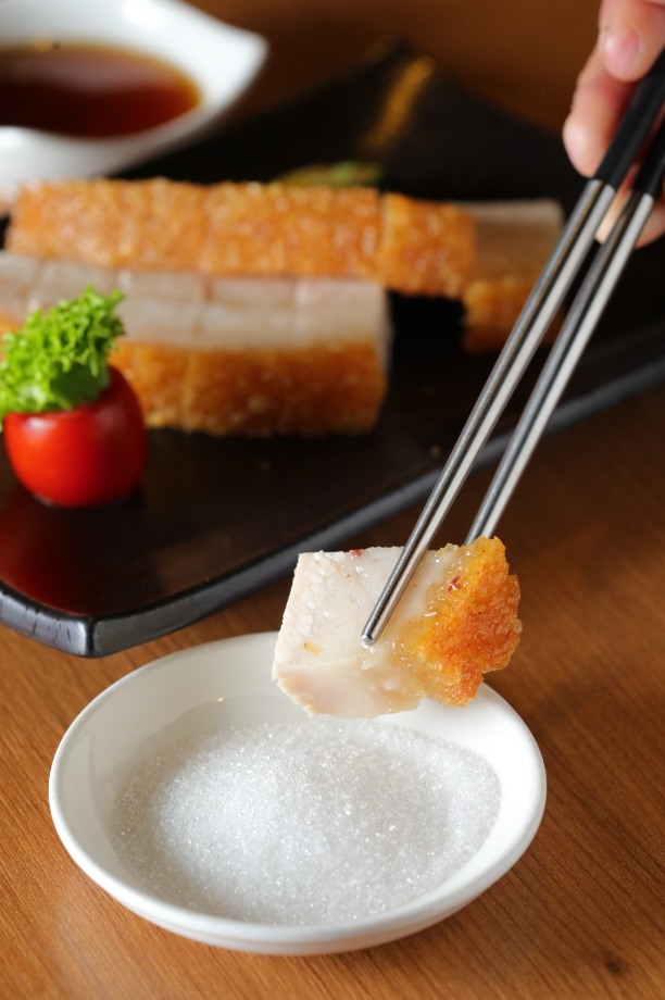 「脆皮燒腩仔」豬皮放涼也超酥脆，蘸上砂糖吃，糖粒隨咀嚼化開，脂甜迷人。（280元／份）