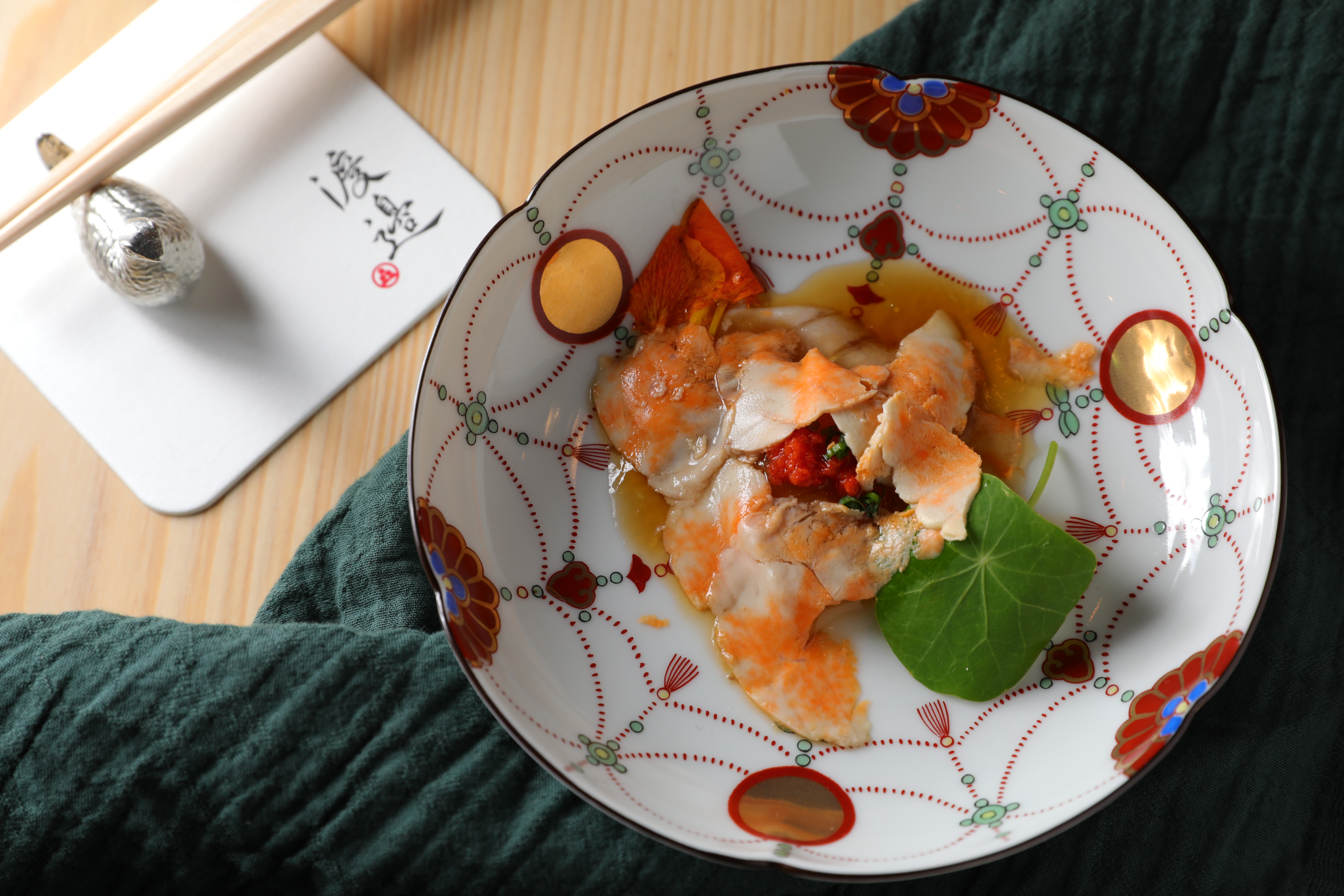 「九繪炙燒生魚片」上的粉橘色薄片即是鮟鱇魚肝，賦予鮮甜生魚片甘美滋味。