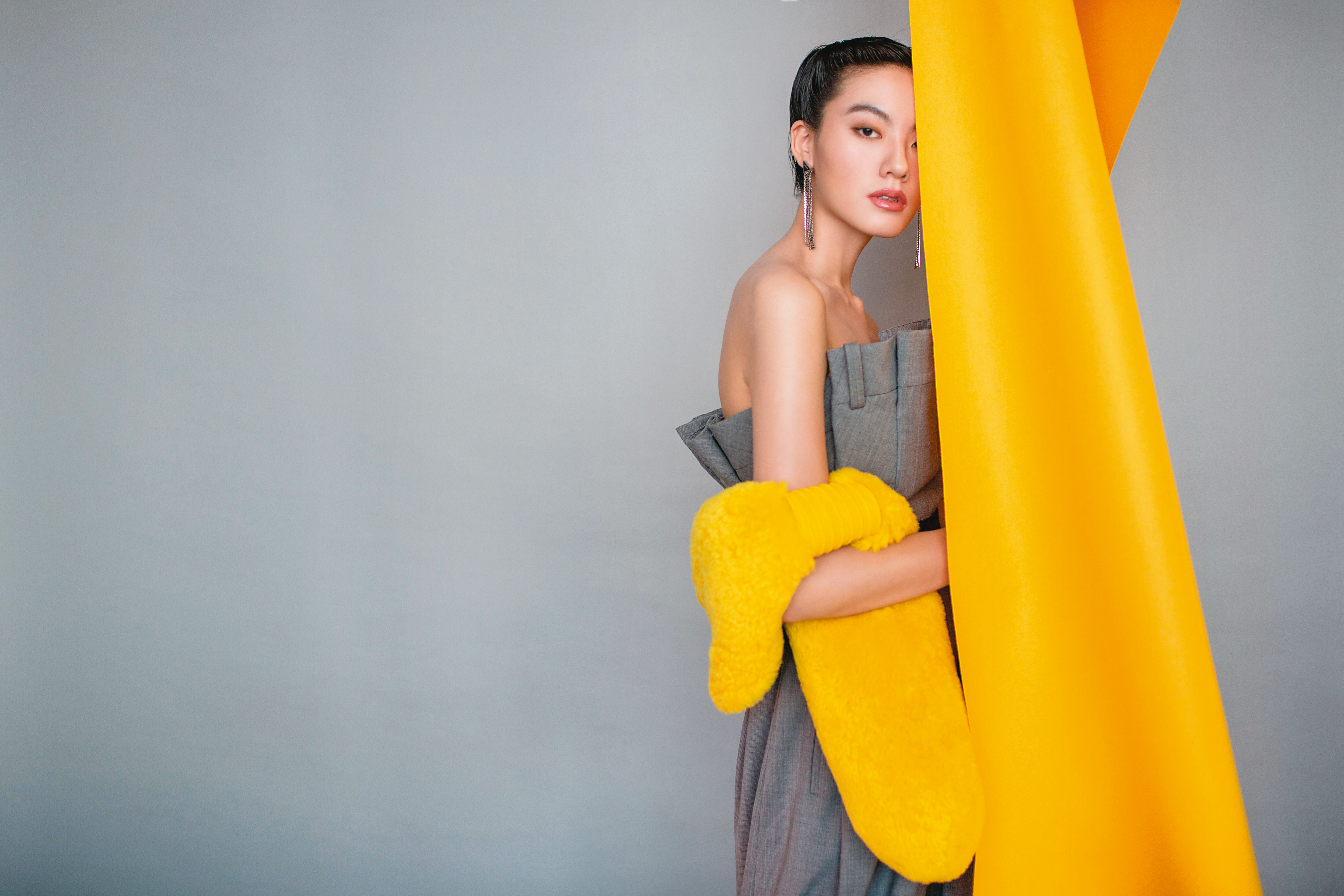 灰色長褲造型連身褲 NT$116,300 by MOSCHINO／黃色翻羊毛長脖圍巾 NT$50,100 by BOTTEGA VENETA／三角標誌流蘇耳扣 NT$14,000／單支 by PRADA／鉛灰色刺繡帆布腰帶 NT$33,000 by Dior