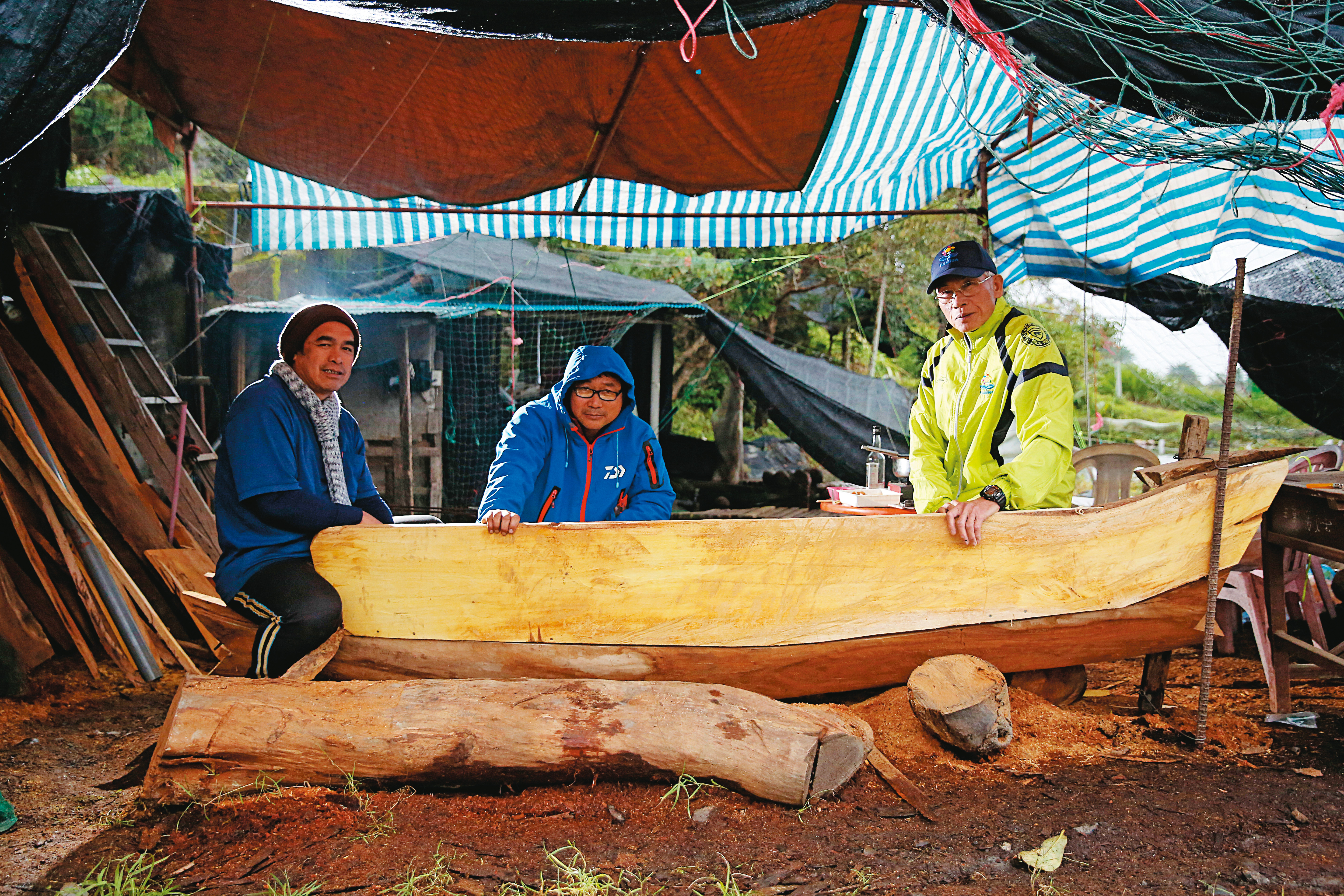 阿美族造舟人林榮康（中）與父親（右）及另一名族人，為了發揚傳統獨木舟文化，在花蓮貓公部落的基地打造獨木舟。