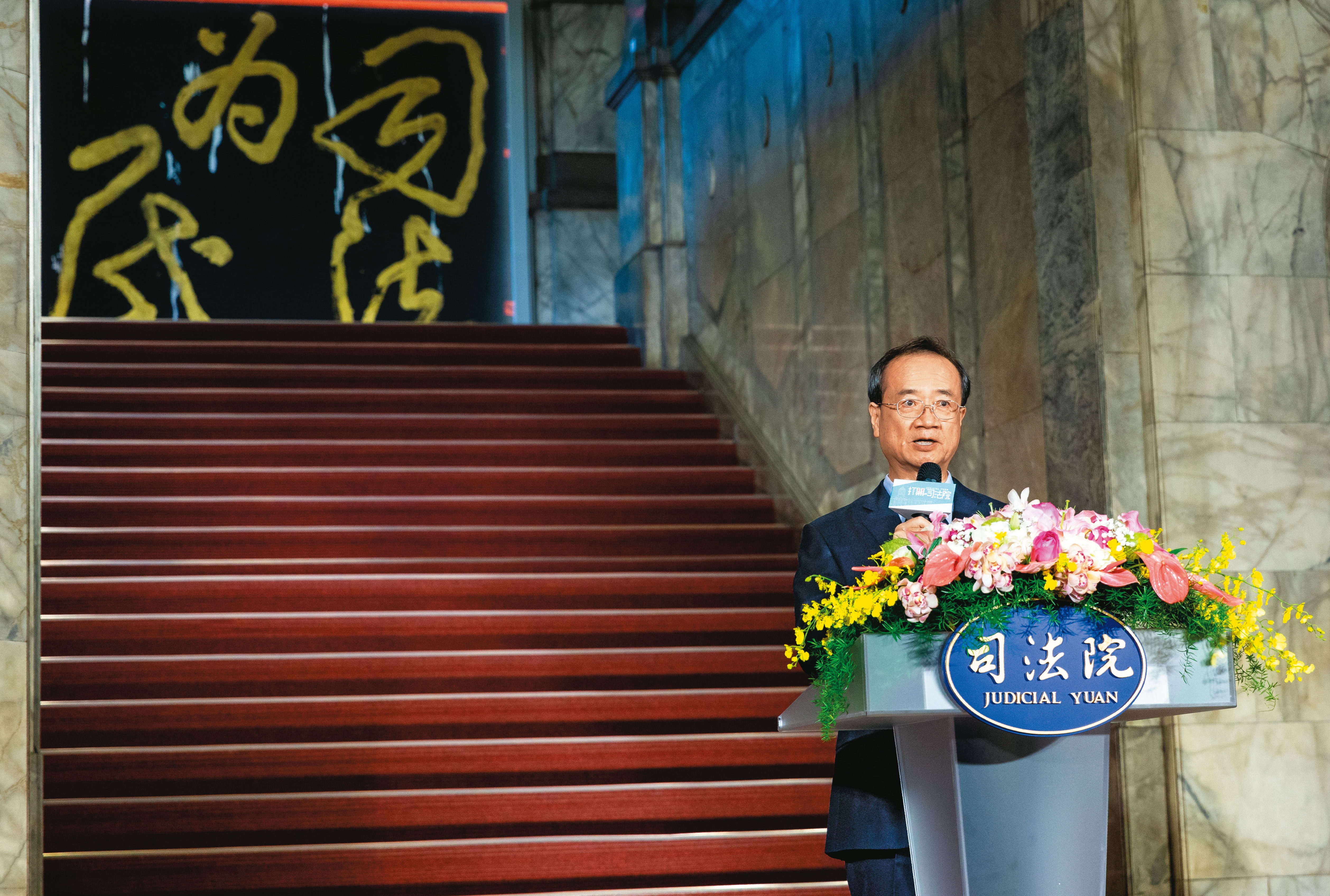 司法院長許宗力日前舉辦開門活動，但至今不願出面對此司法醜聞表態，他背後斗大的「司法為民」字眼，看來格外諷刺。