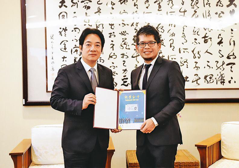 為鼓勵超級菁英回台,國發會2018年核發第一張「就業金卡」給陳士駿(右)。左為時任行政院長的賴清德。(國發會提供)