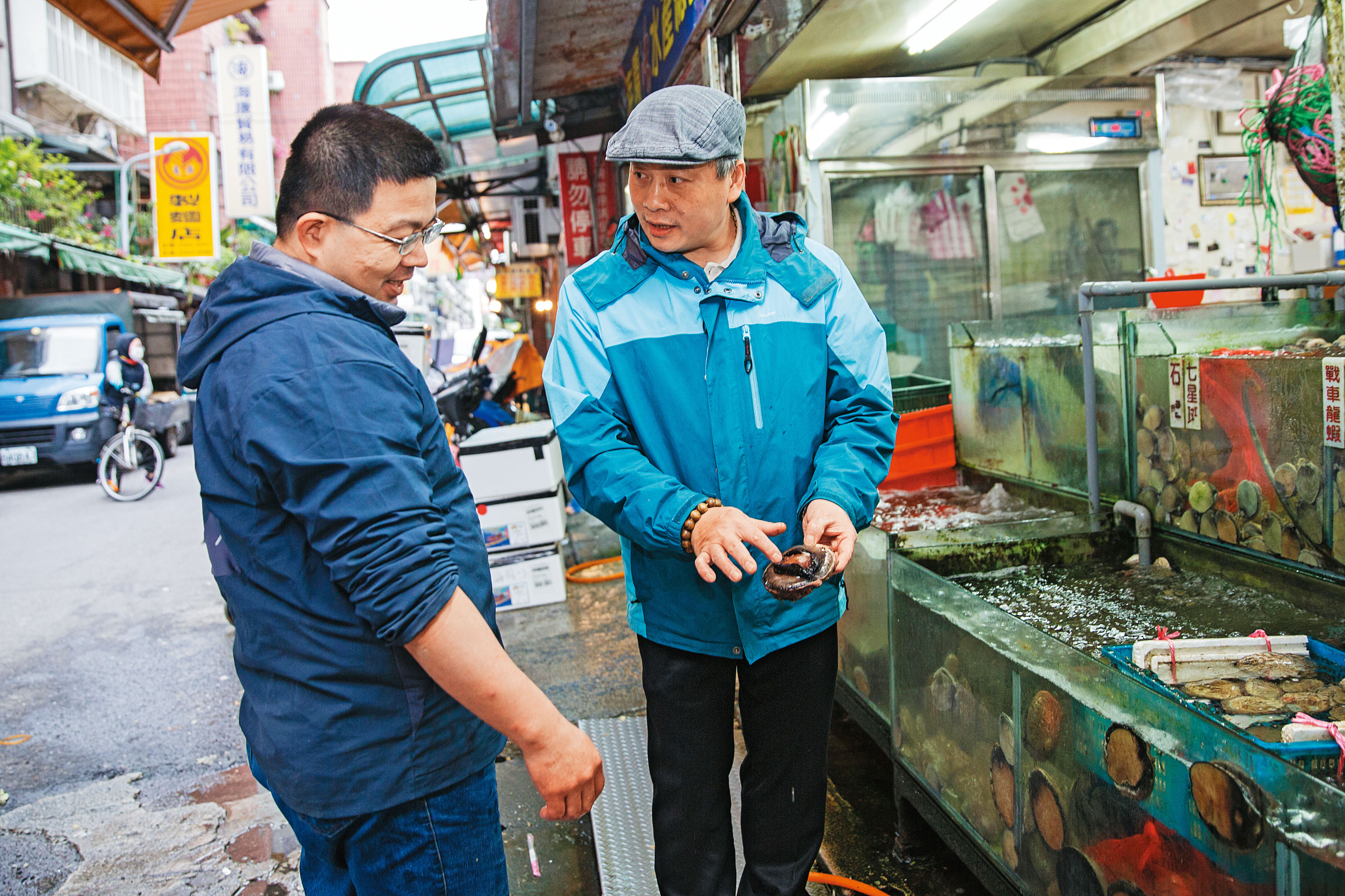 阿興師（右）現在就近到濱江漁市的海園活水產挑高檔魚貨。