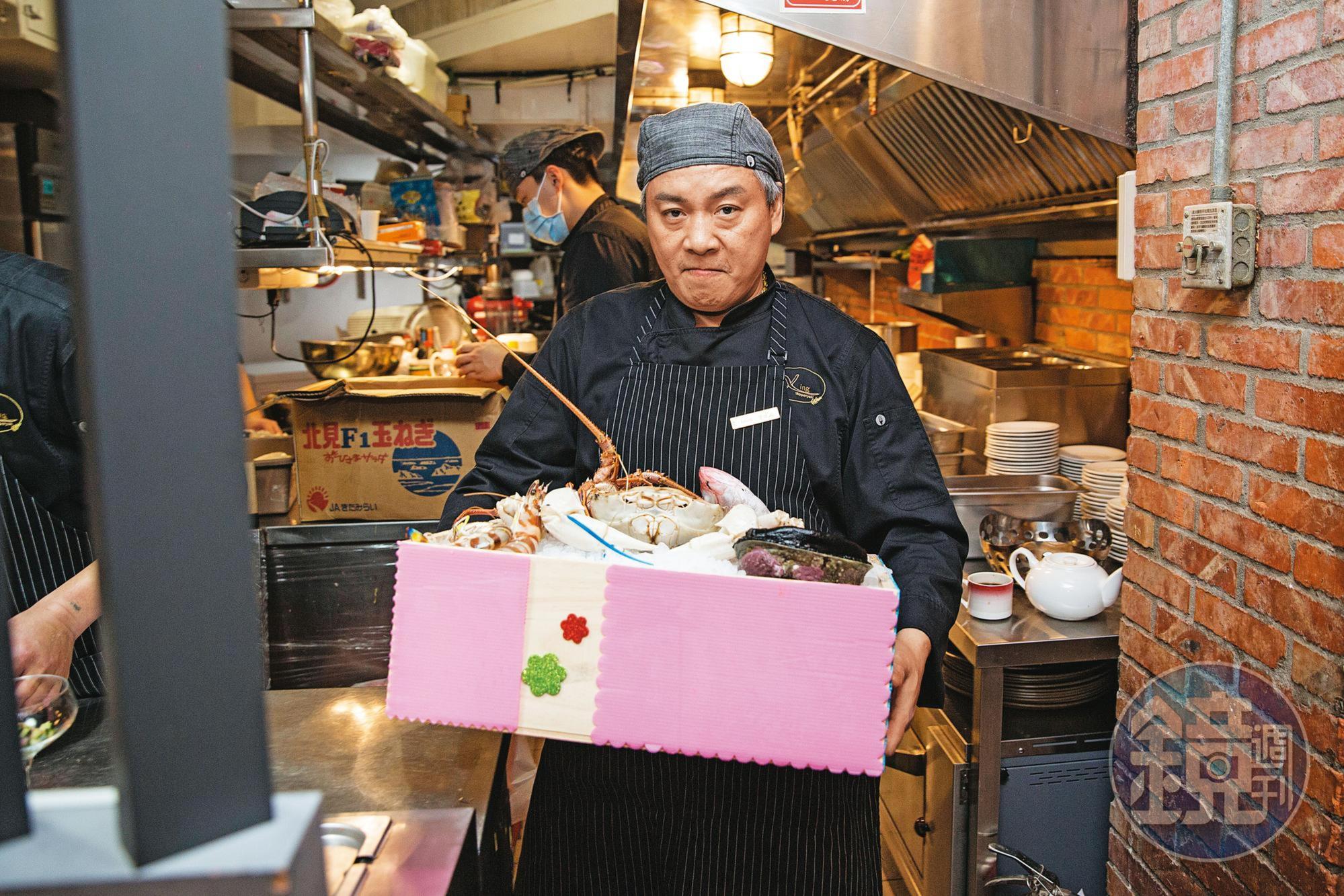 阿興師（前）搬出1箱時令頂鮮食材，要去煎檯秀給客人看。鱈場蟹、活鮑魚都需提前預訂。