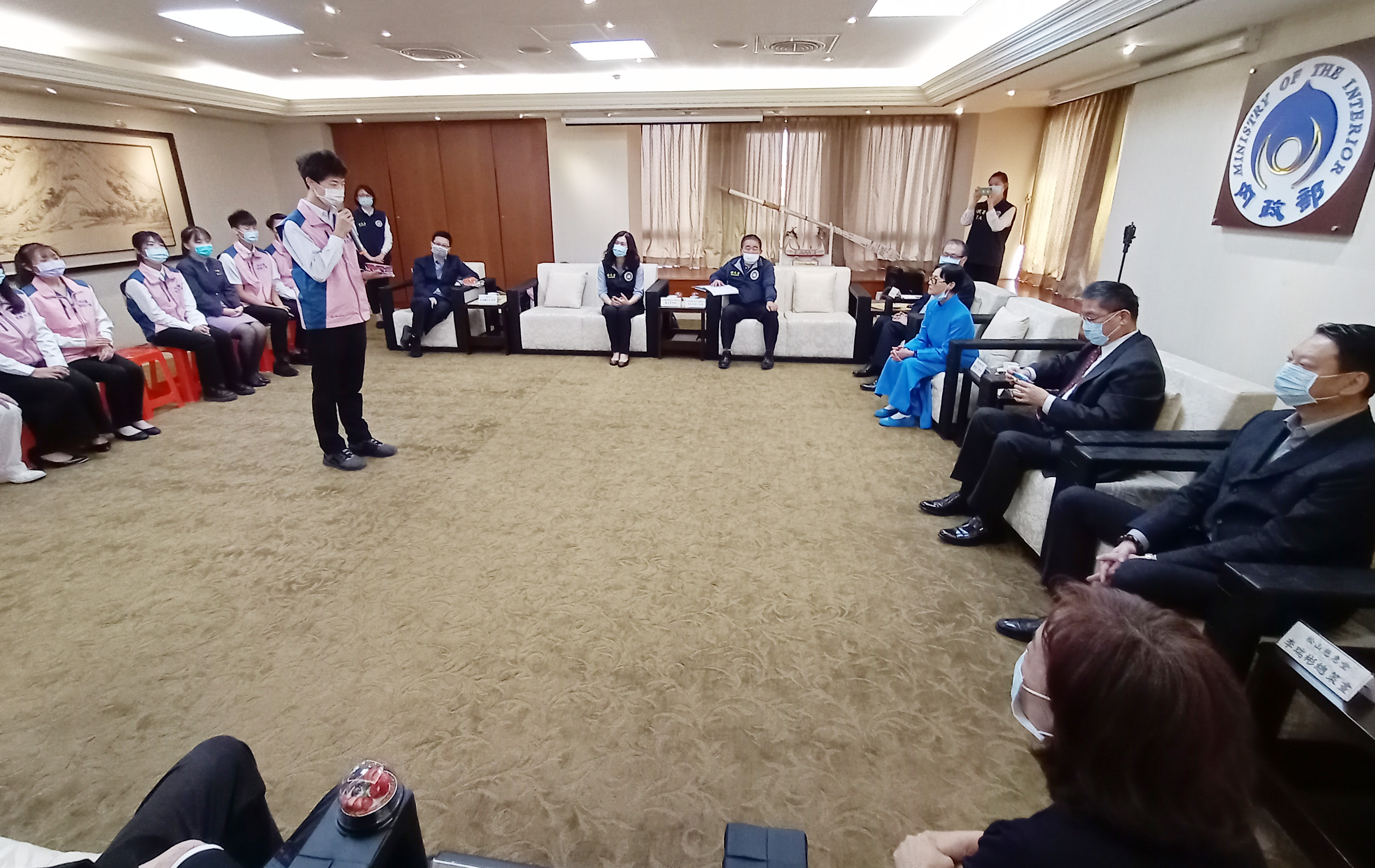曾國揚展示自己製作的手工模型公車，徐國勇把玩直說「精緻」。（移民署提供）