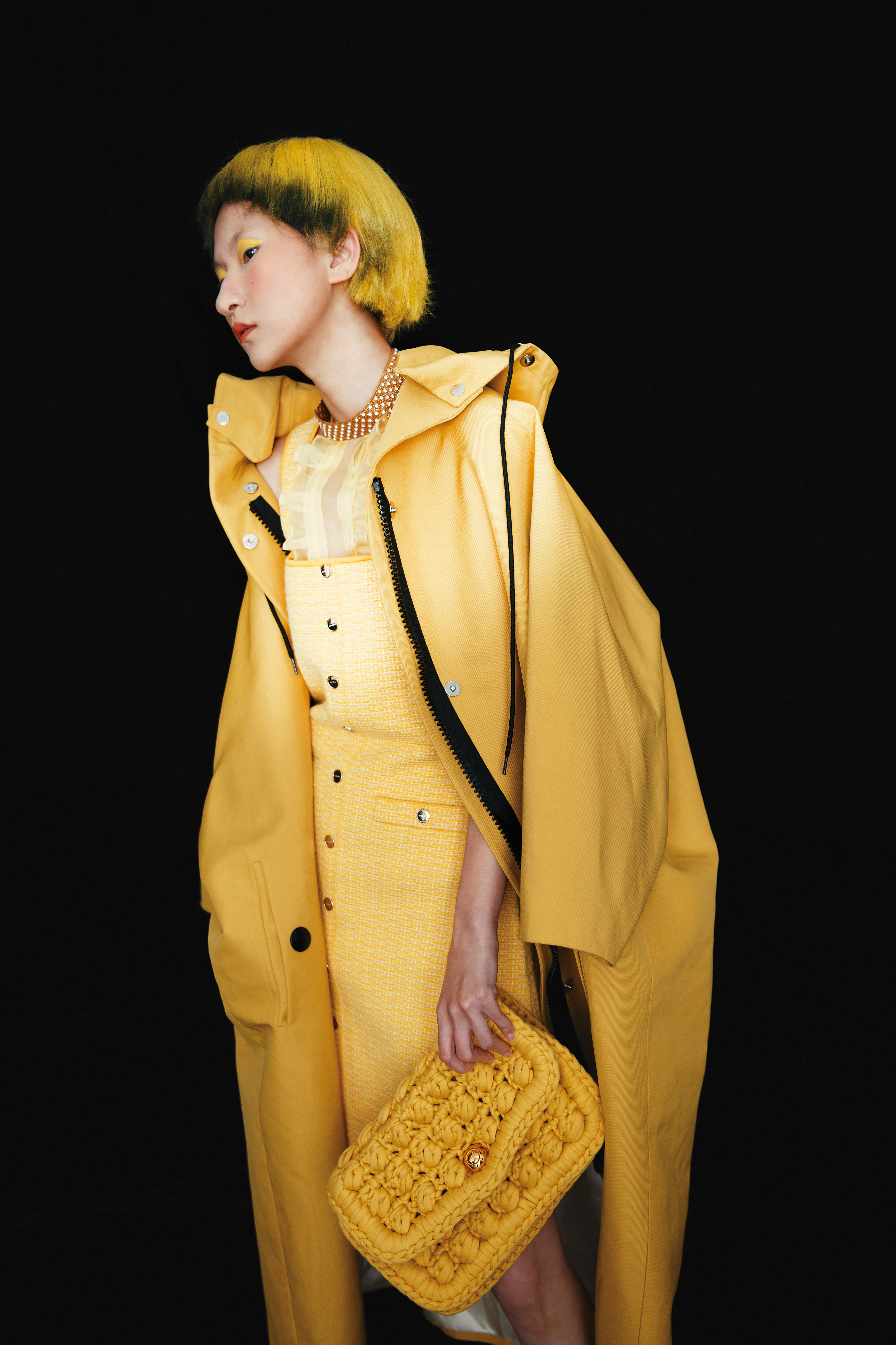 芥末黃風衣NT$115,000 by PRADA／黃色吊帶洋裝NT$11,360 by sandro／荷葉薄紗挖背背心 價格店洽 by MIU MIU／奶油黃棉質鉤針金鍊包NT$143,000 by BOTTEGA VENETA