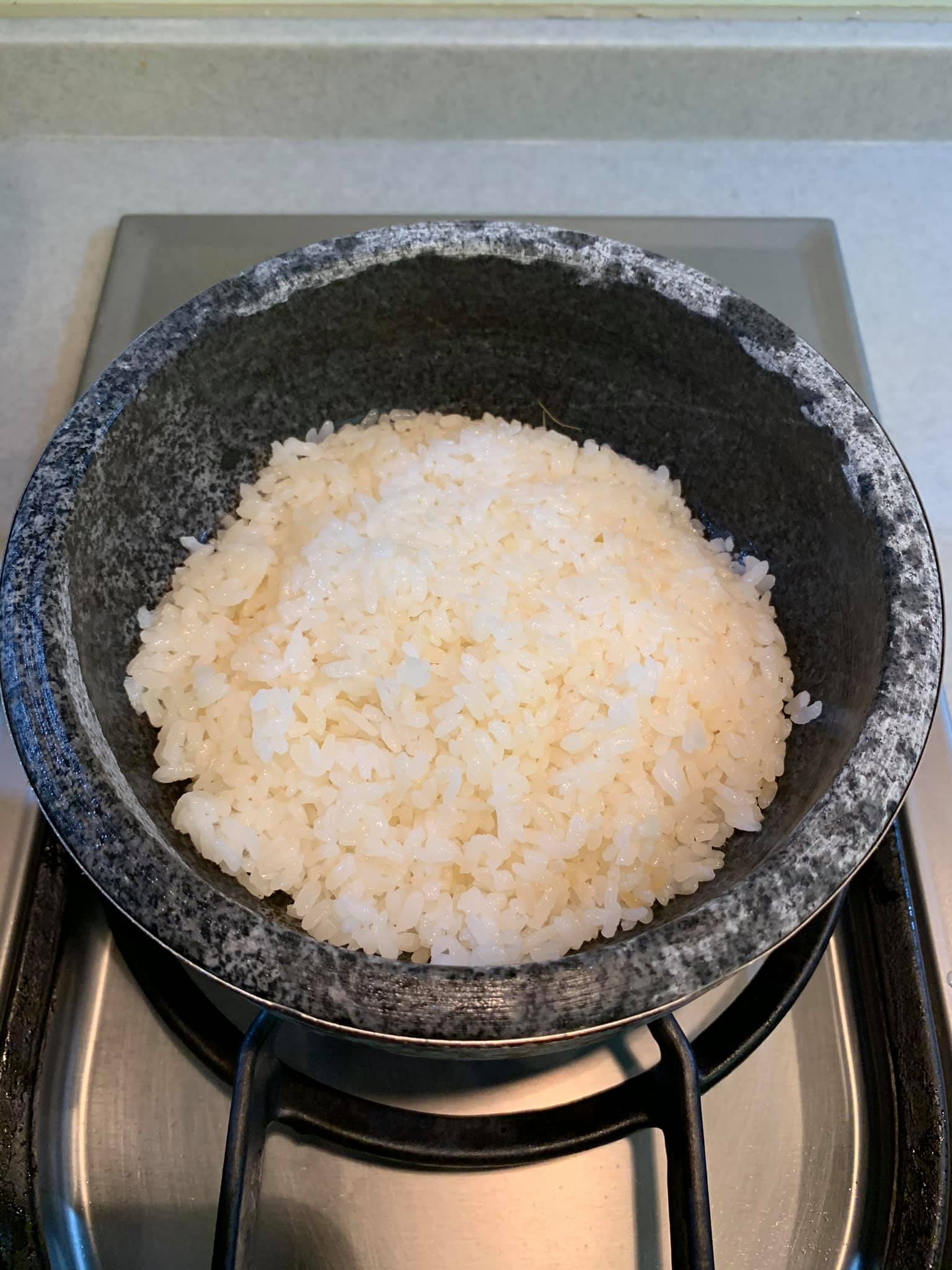 將飯放進石鍋，準備炙燒做鍋粑。