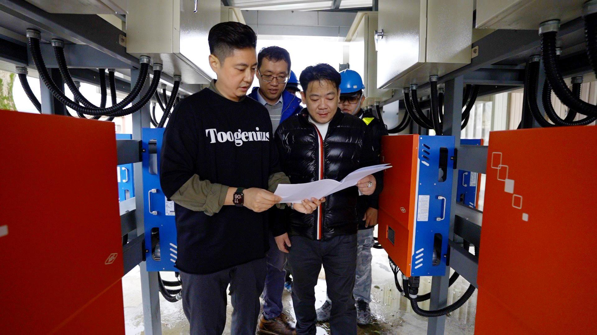隆電光能總經理廖世民(右)與田總解說完工電廠設備概況。