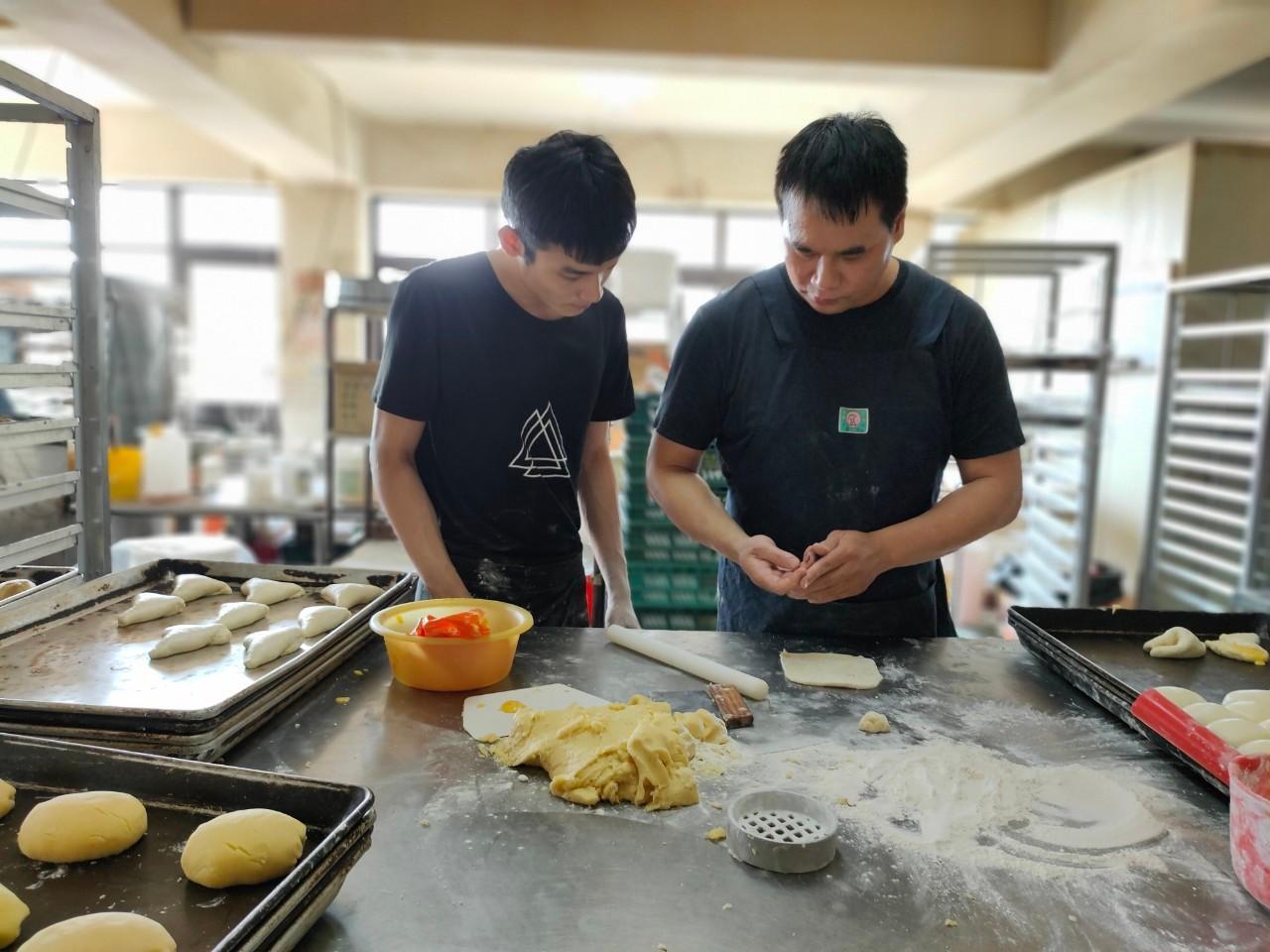 阿林認真學習主廚教的新手法,麵包捏的漂亮才賣的出去。(頂新和德文教基金會提供)