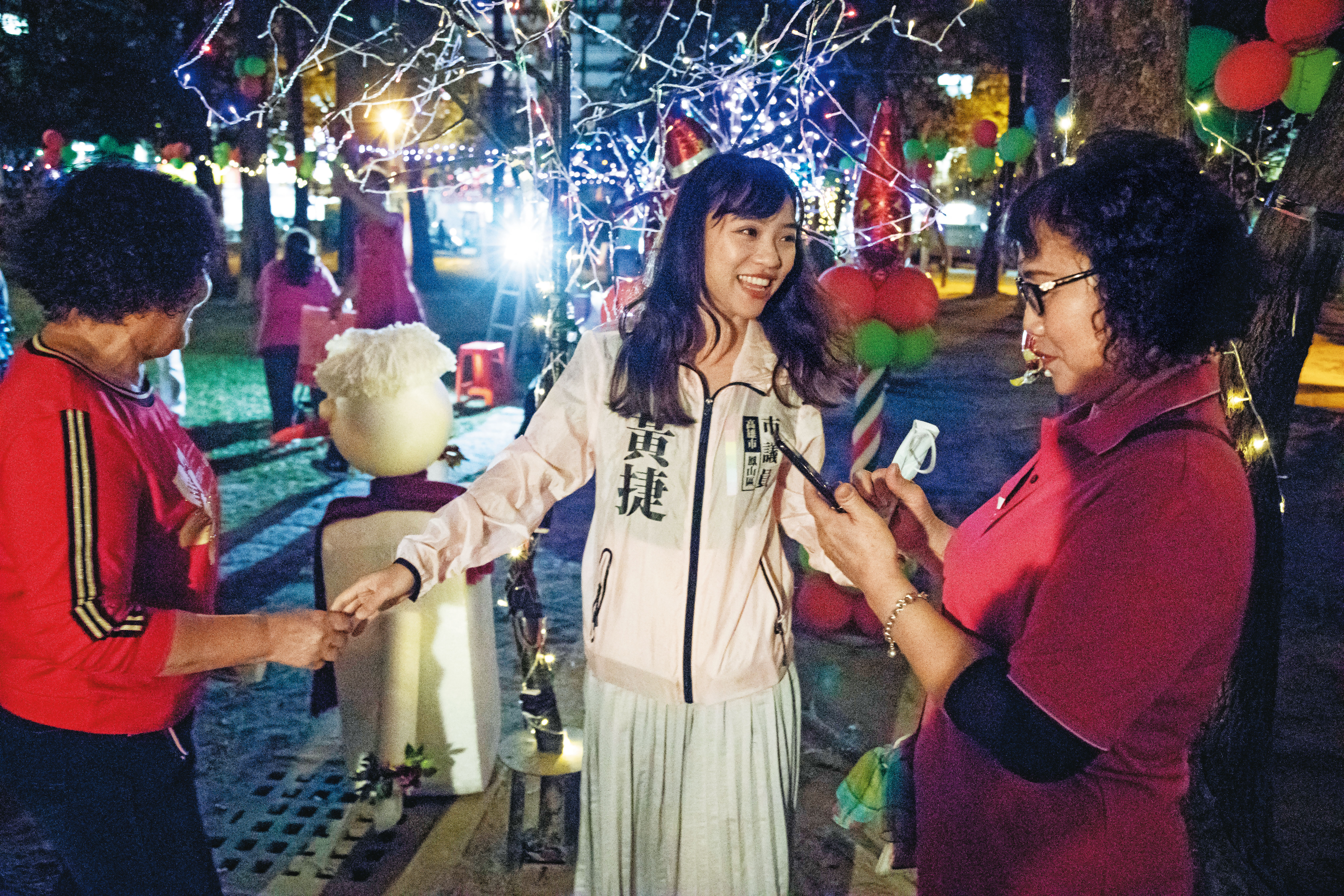 黃捷（中）在里民活動熱情與民眾寒暄，但還是顯得生澀，經常發出一連串哈哈哈的笑聲。