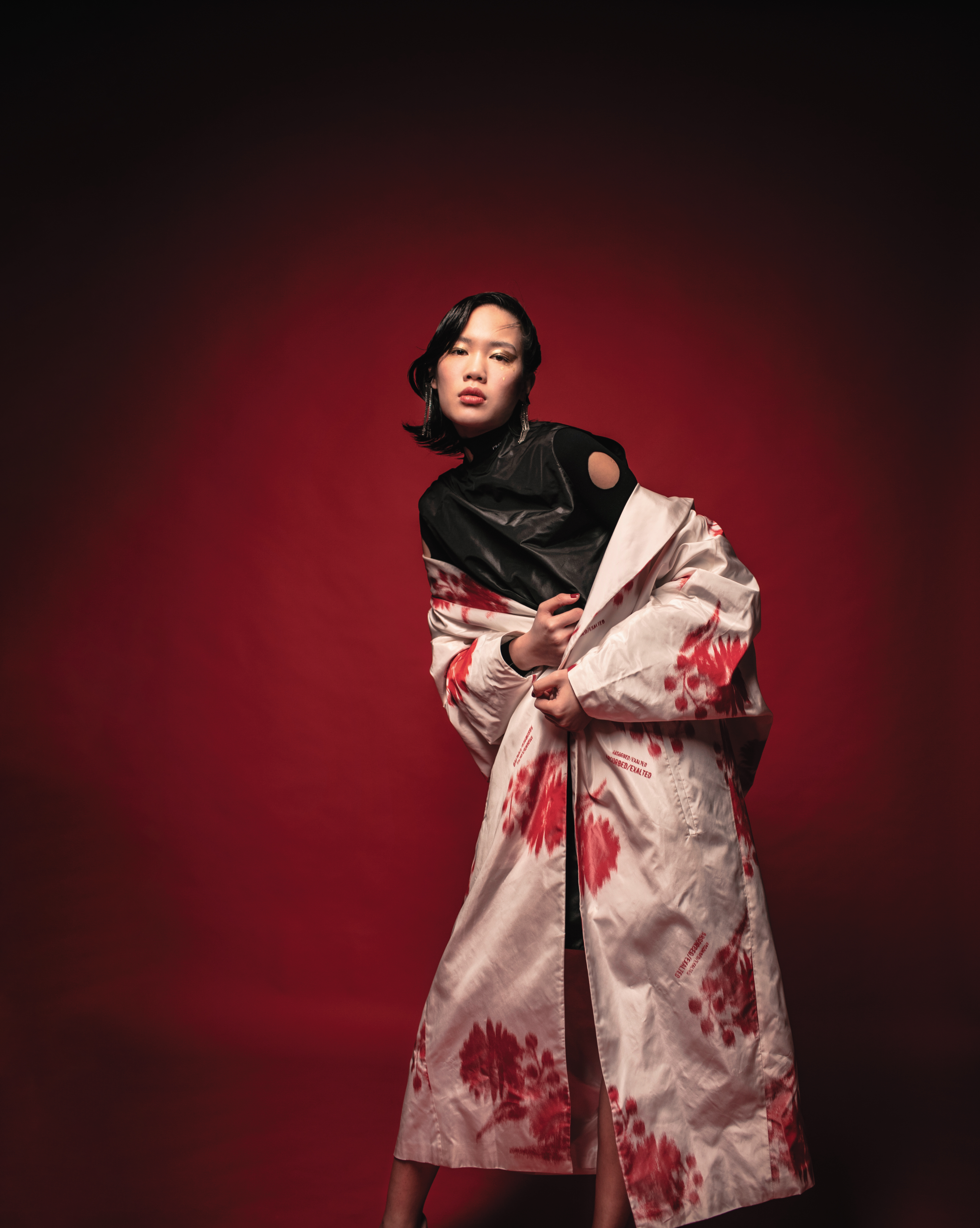 PRADA紅色印花風衣（價格店洽）、PRADA黑色洞洞內搭上衣（價格店洽）、PRADA黑色尼龍連身裙（價格店洽）、PRADA三角Logo流蘇耳環（價格店洽）。