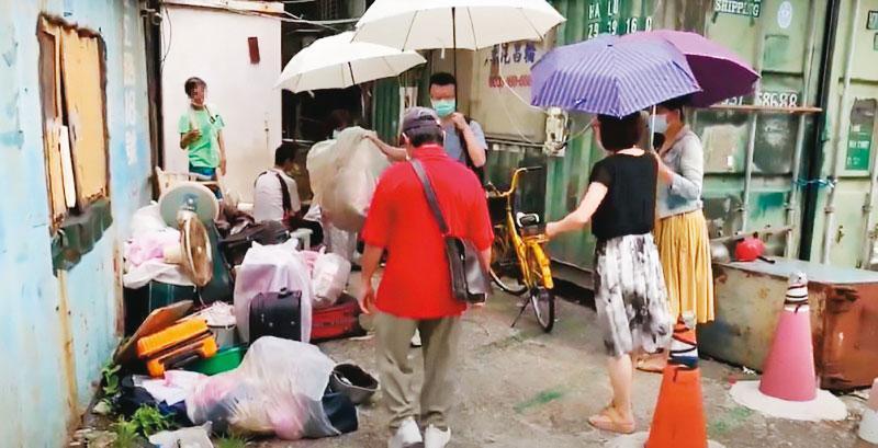 南港區公所協同各局處單位會勘後,協助住民將垃圾打包清出。(南港區公所提供)