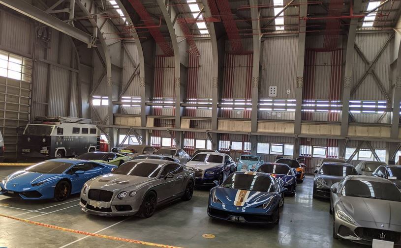 檢調搜索莊周文公司住處，查扣13輛跑車，陳列贓證物現場，現場猶如超跑俱樂部。（讀者提供）