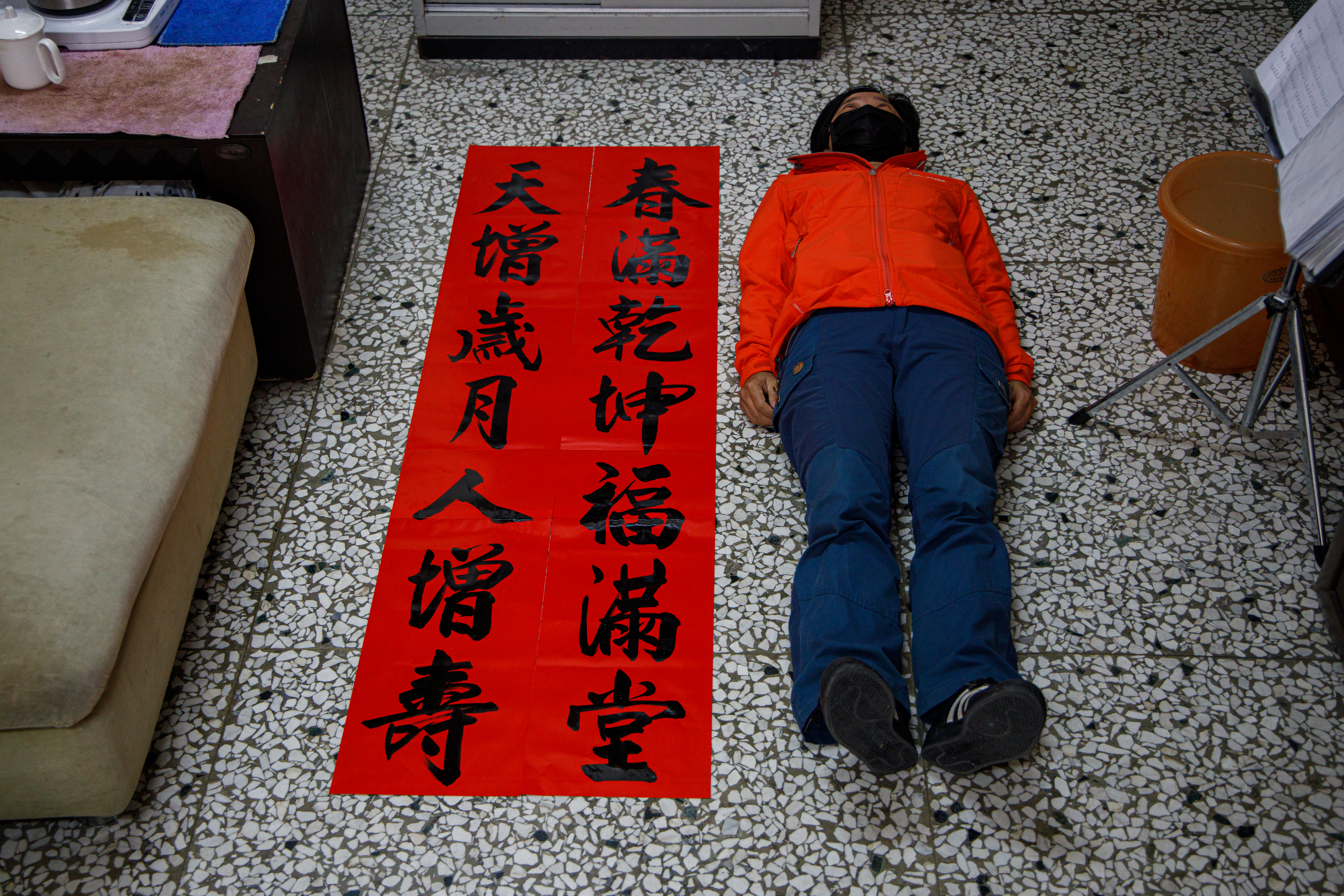 剛寫好的春聯需要放在地上晾乾，很胡鬧地請同事躺在地上當比例尺。