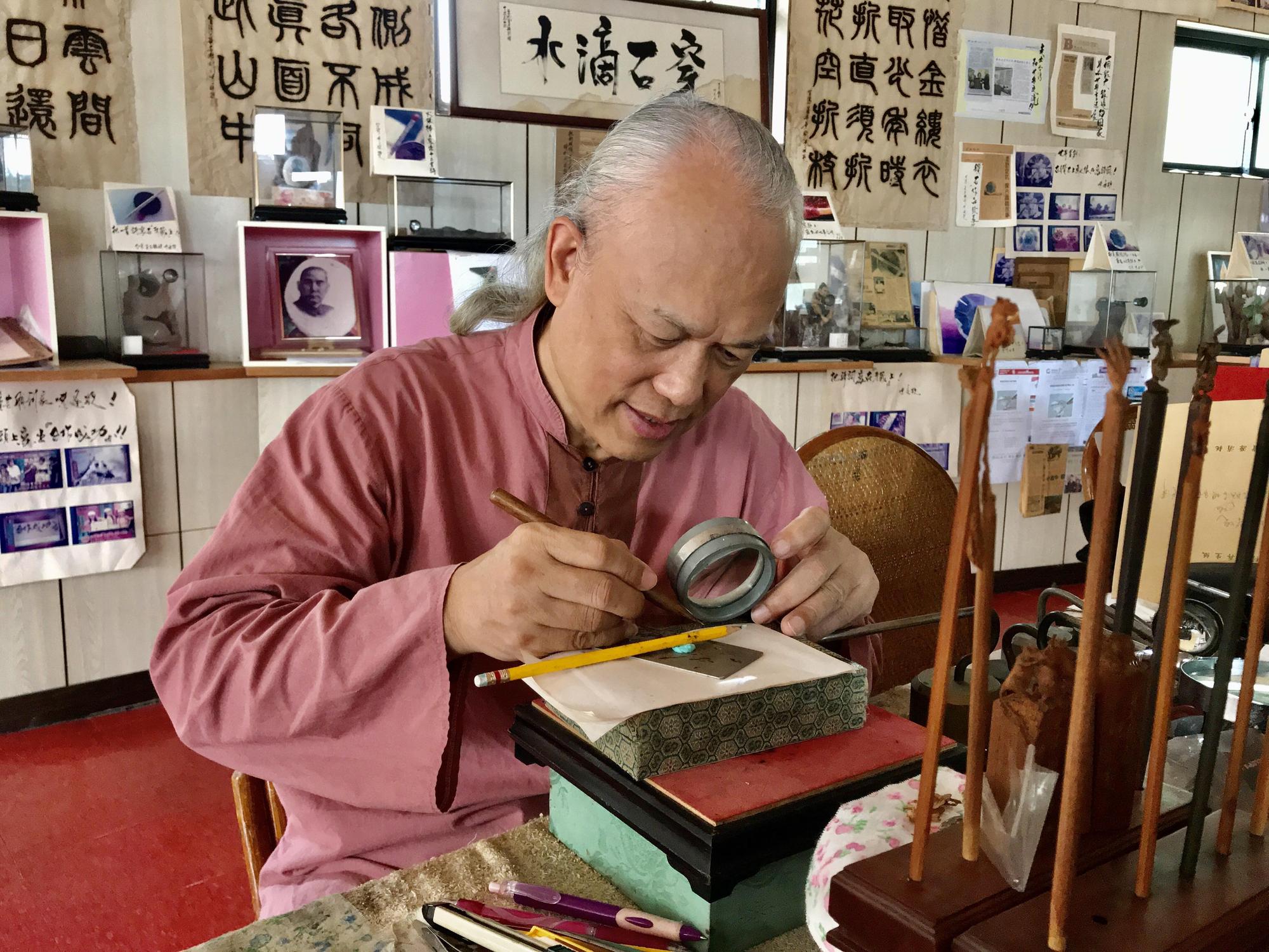 毫芒雕刻家陳逢顯以純黃金手工雕刻世界最小「黃金台灣水牛」，尺寸約只有1毫米。（陳逢顯提供）