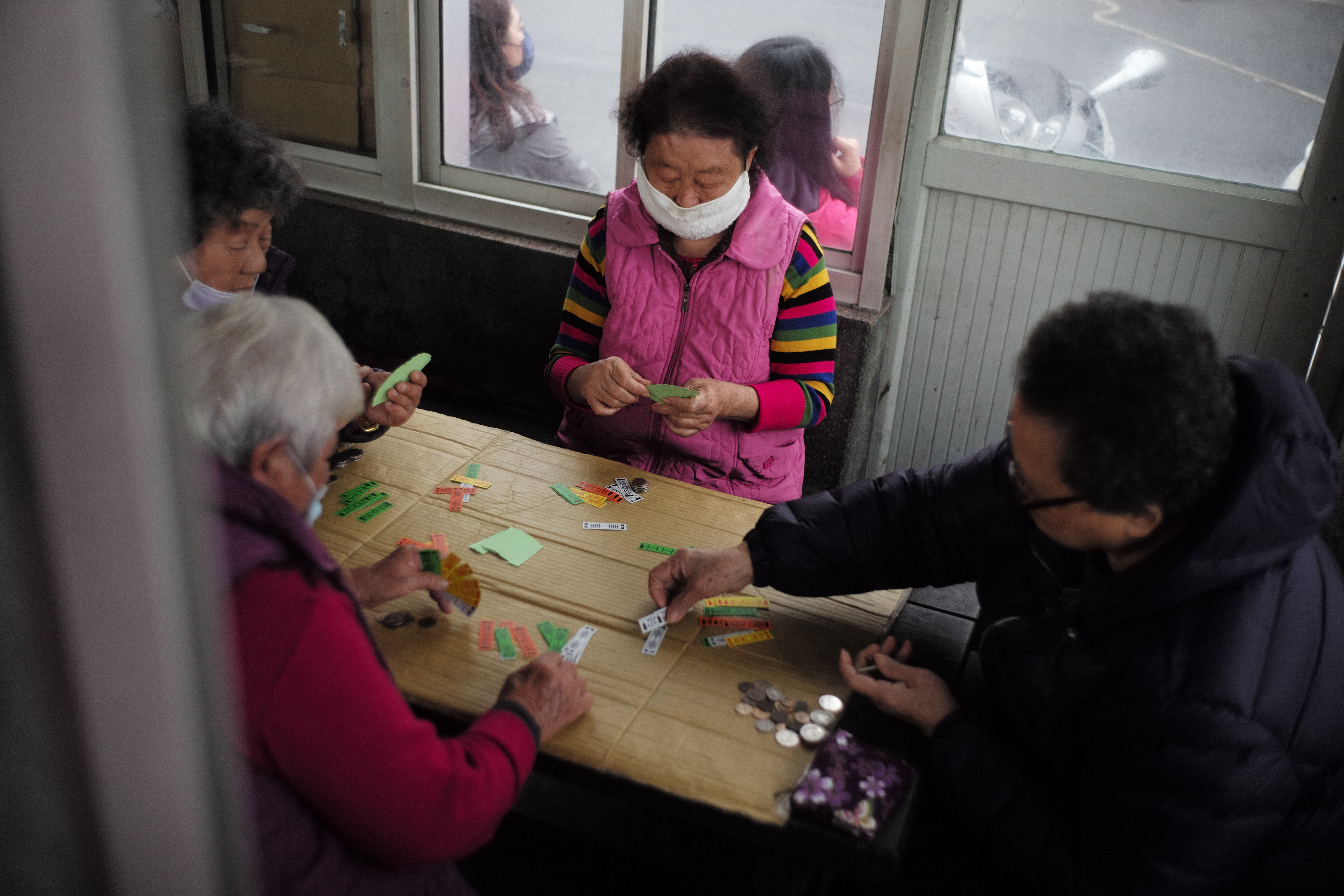 過年時村民一同相約在放漁具的倉庫內玩四色牌。