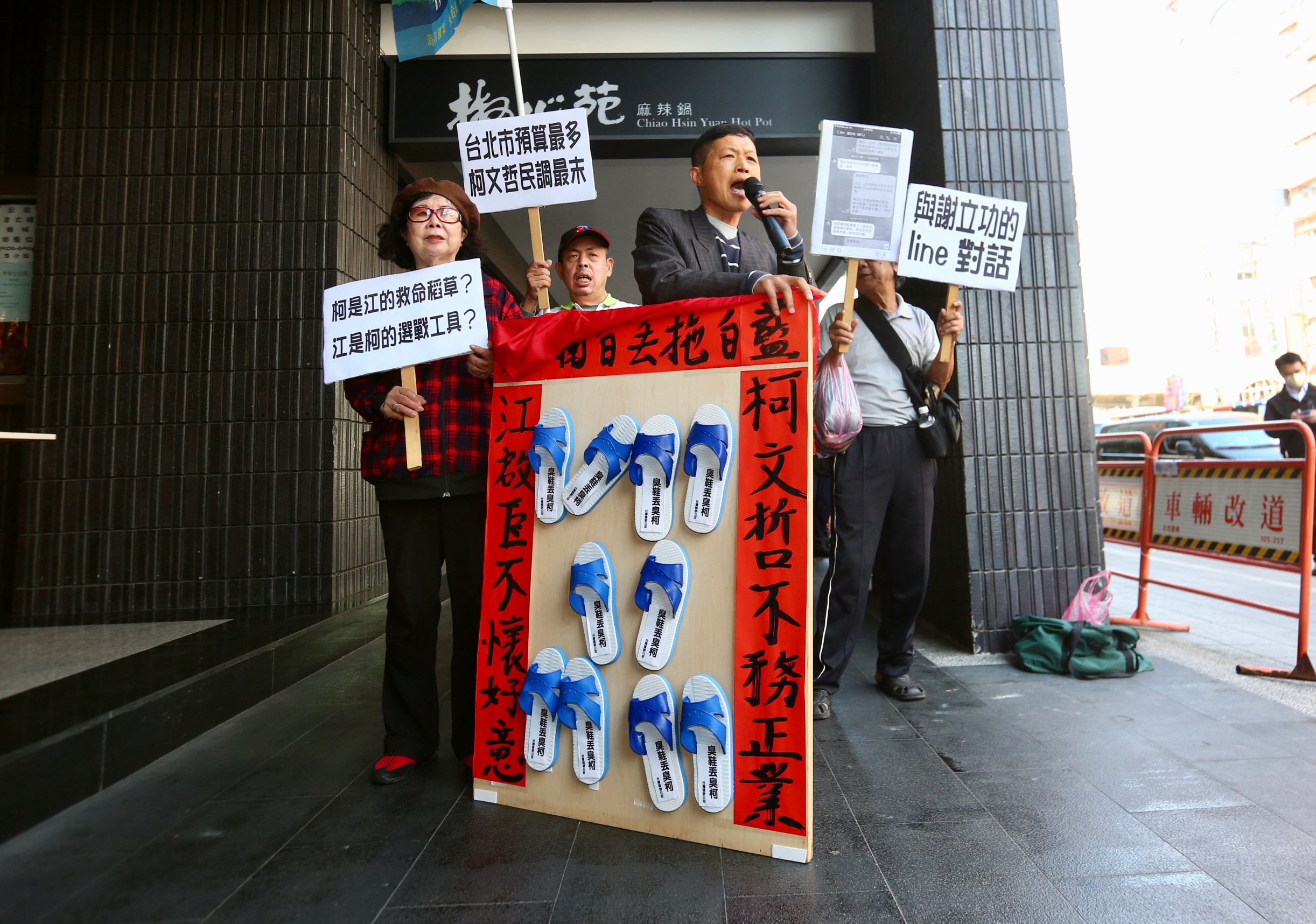 柯文哲、江啟臣24日上午出席願景台灣2030論壇活動，場外台灣國成員眾以藍白拖暗喻藍白各懷鬼胎。