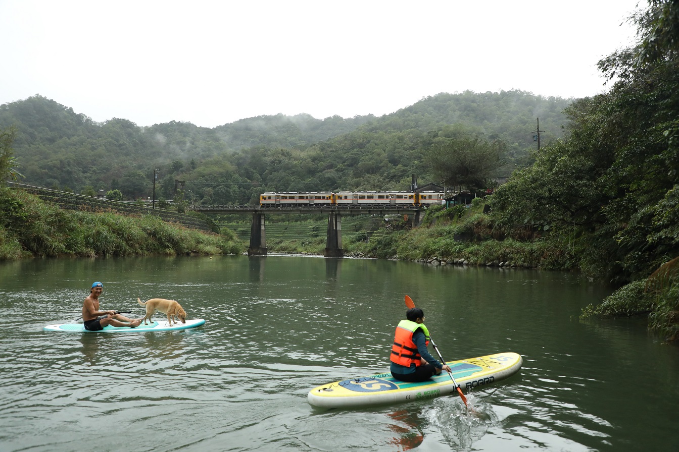 基隆河在三貂嶺一帶形成平坦的水域，可以在上頭划SUP，在水道上也可以看見火車在橋上行駛而過的景觀。