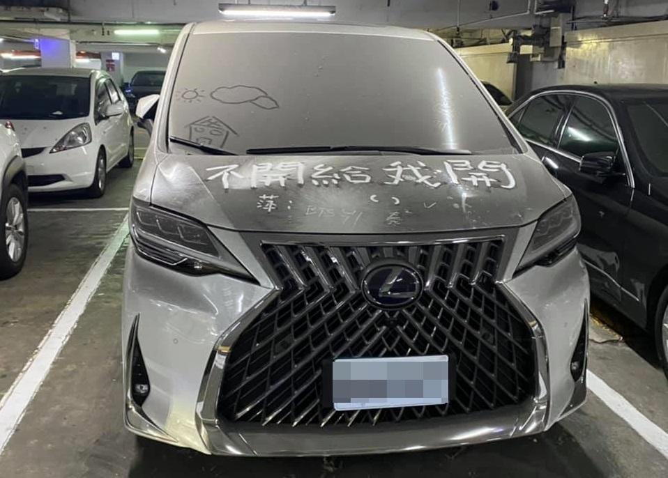 民眾發現停車場內停著一台Lexus新車上面積滿灰塵,引來路人嫉妒畫字「不開給我開」。 (翻攝自爆廢1公社)