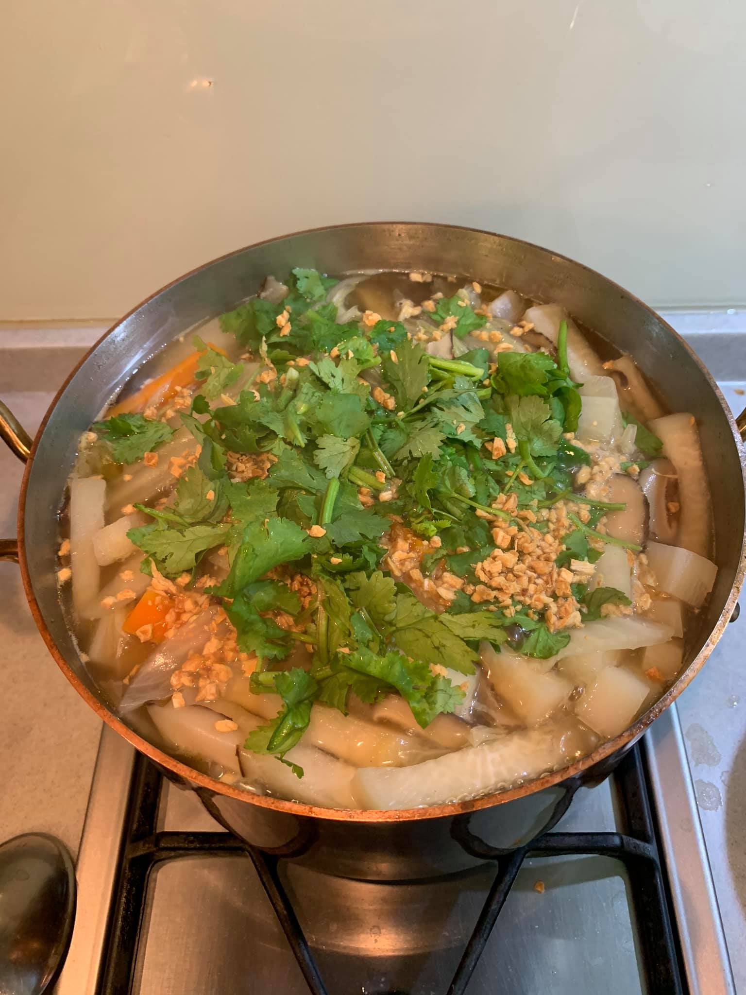 在備好的羹湯上，撒上蒜酥、香菜，先不放魚。
