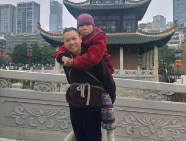 陳湘背著81歲癱瘓老母親在貴州旅遊，完成母親想到貴州的心願。（翻攝自阿里巴巴天天正能量微博）