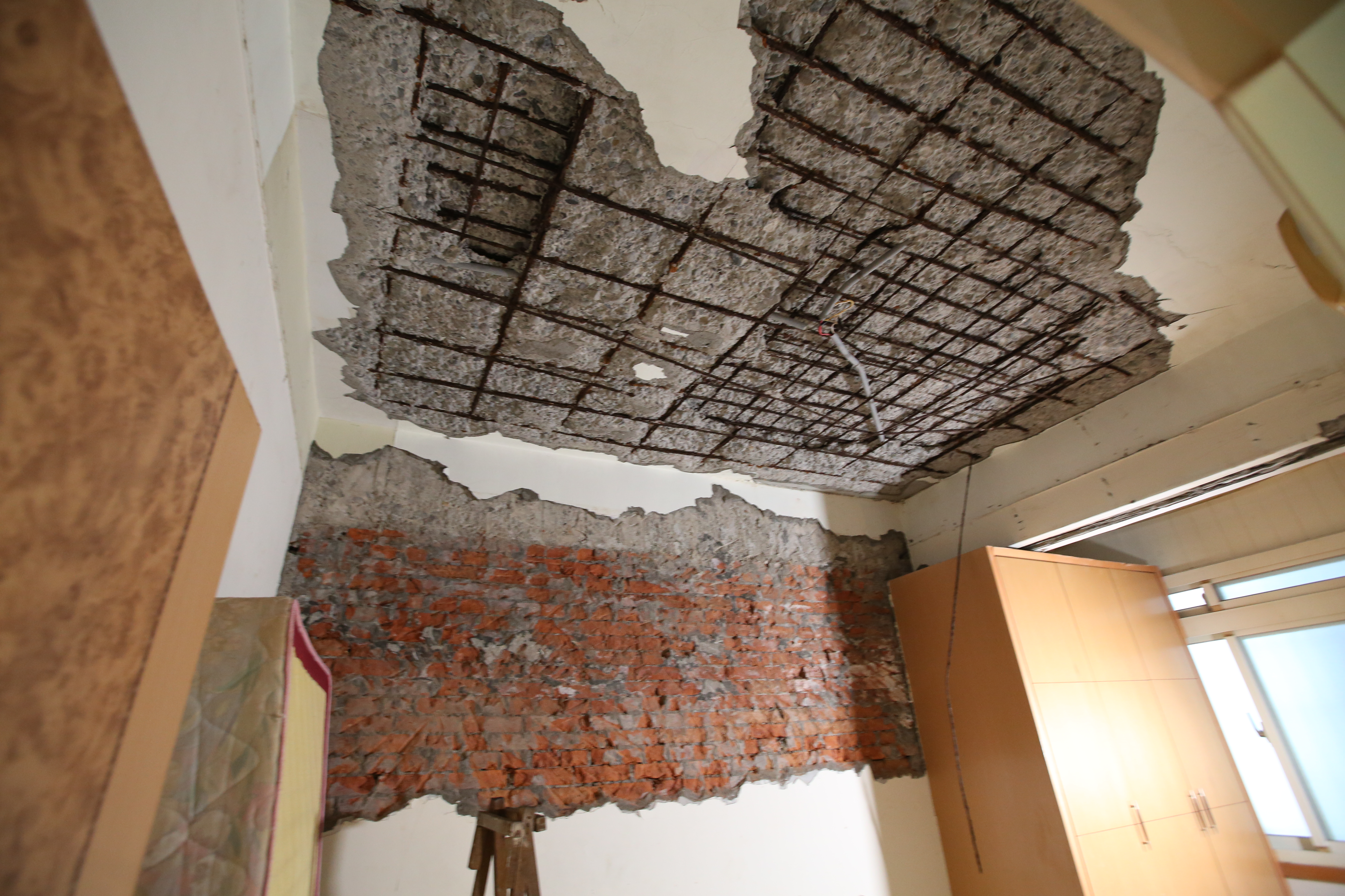 住戶的屋內有大片水泥崩落，還造成鋼筋外露。