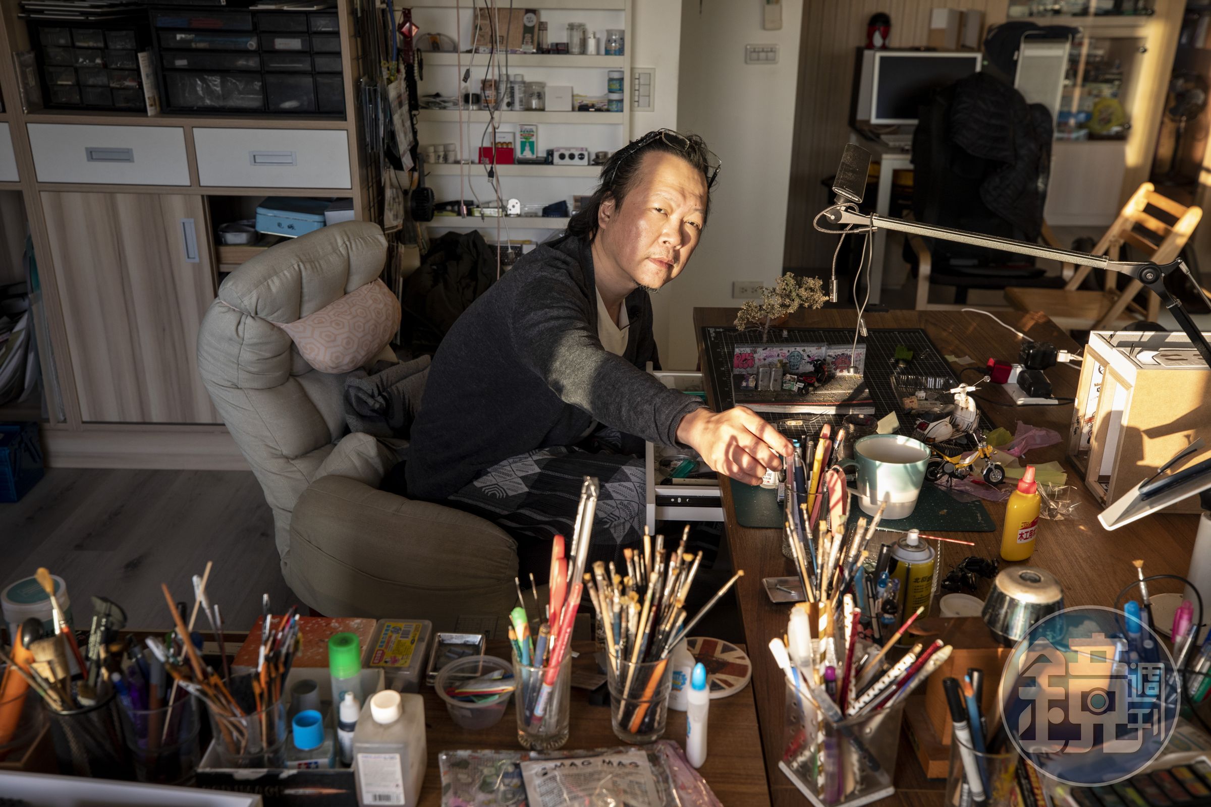鄭鴻展的工作桌充滿各類工具與微縮物件，因為平面與室內裝修設計的工作歷練，讓他得以掌握各種材質的運用。