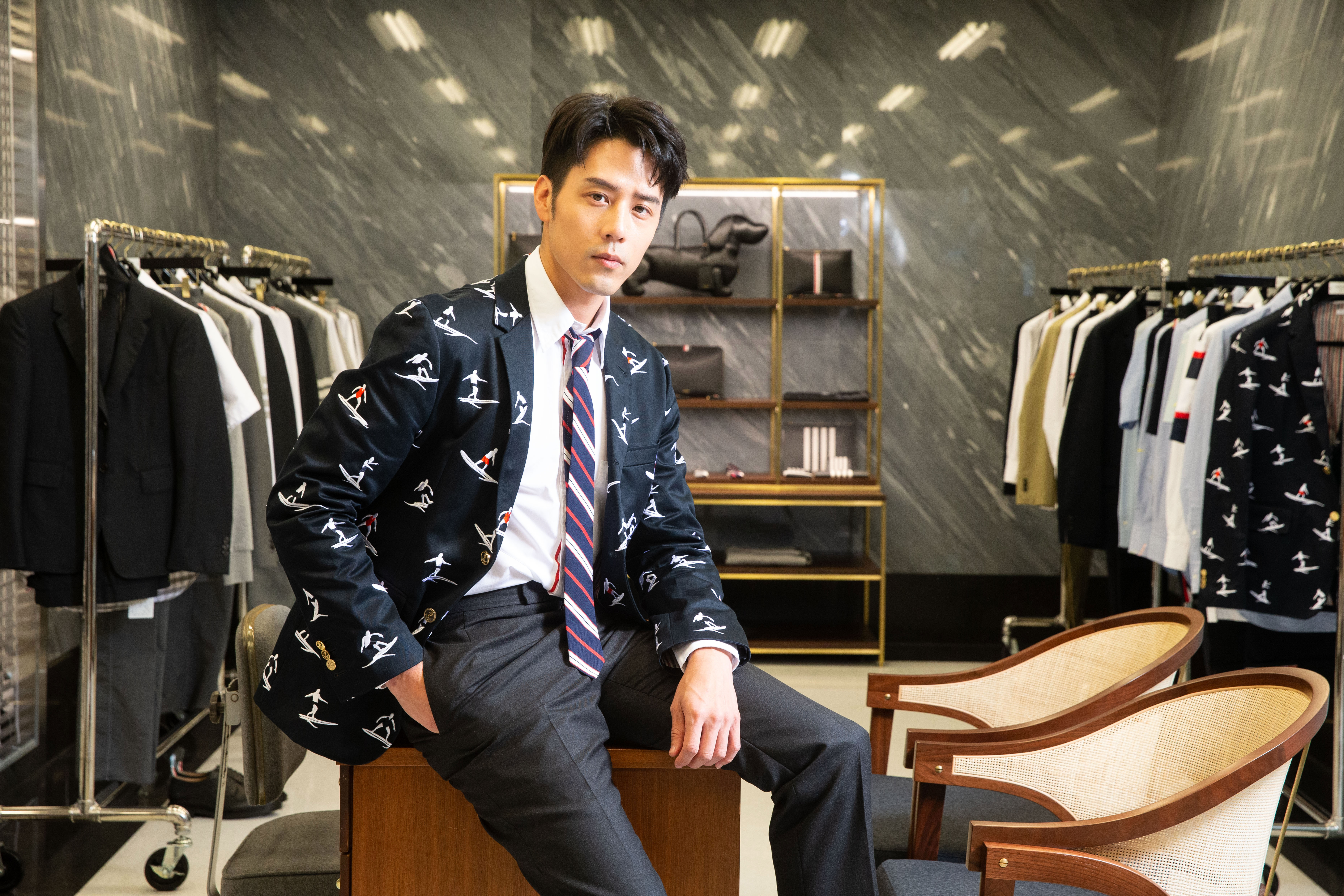 胡宇威不顧腳痛也要塞進THOM BROWNE經典的緊身西裝裡。 深藍衝浪刺繡西裝外套 NT$81,600、深灰西裝褲(搭配成套西裝外套販售) NT$84,200、白色襯衫 NT$15,100、紅藍白條紋領帶 NT$8,200、黑色雕花皮鞋 NT$23,600  THOM BROWNE（THOM BROWNE提供）