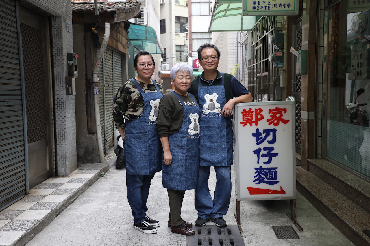 老店家的第二代頭家嬤鄭辛春足（中）和兒子鄭志峰（右）、媳婦（左）陳秋伶，全家人同心經營這間90年老麵店。