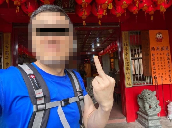 相簿中的男子在宮廟門口比中指自拍，引發爭議。（翻攝自爆料公社）