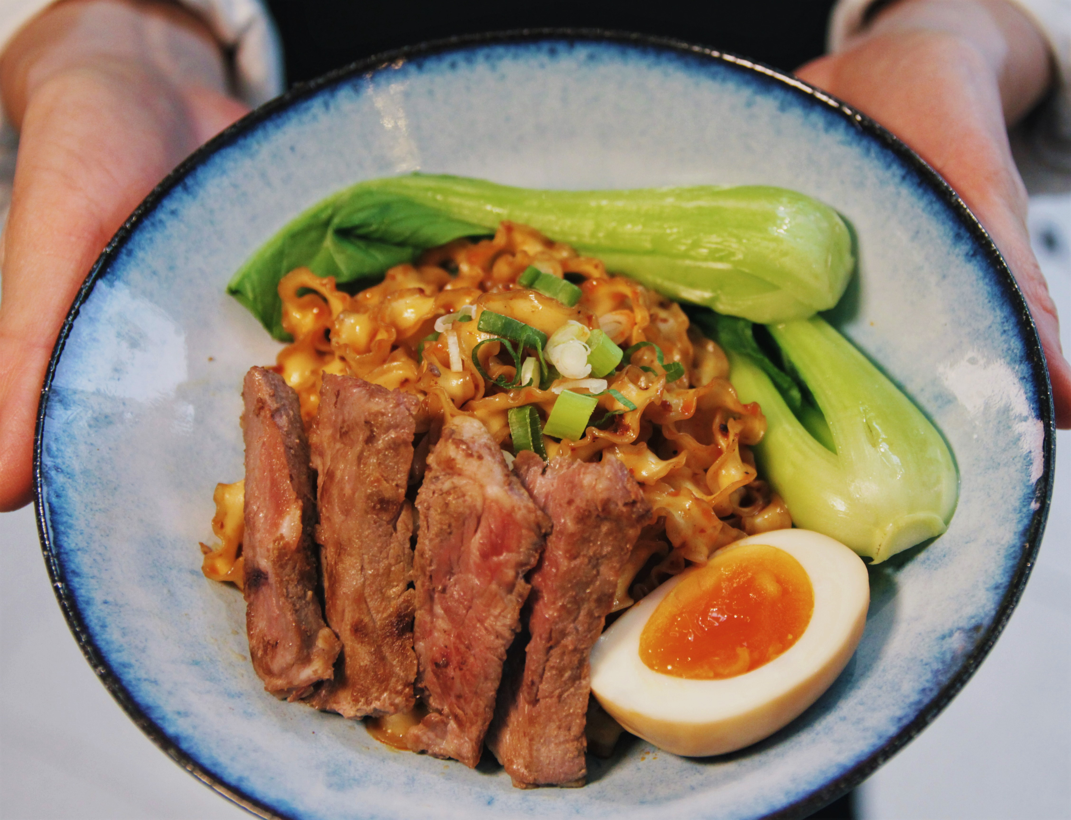「麻辣肋眼熟成牛排乾拌麵」有著澳洲牛的多汁甜嫩與麻辣香。