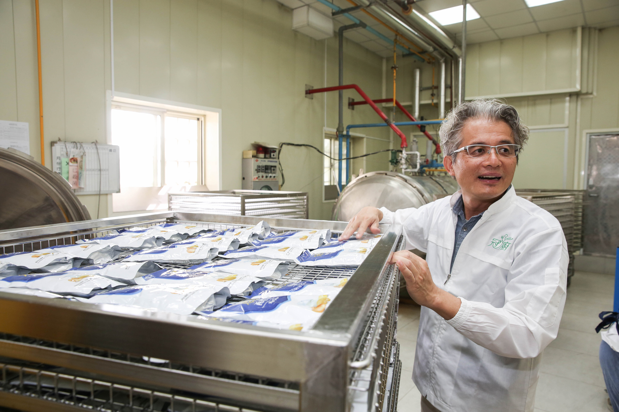 陳宏賓（右）研發出的醬料包，透過機器用120度高溫殺菌，常溫下可保存2年。